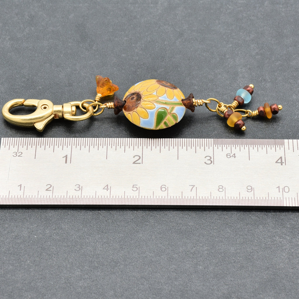 Colorful sunflower handbag charm with gold swivel lobster clasp next to a ruler for scale - handmade with love by Ruby Acorn