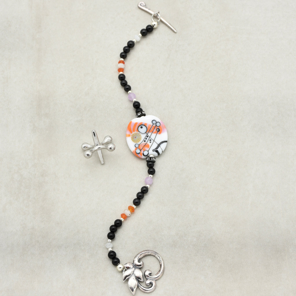 Decorative keychain with beads and charms on a beige background