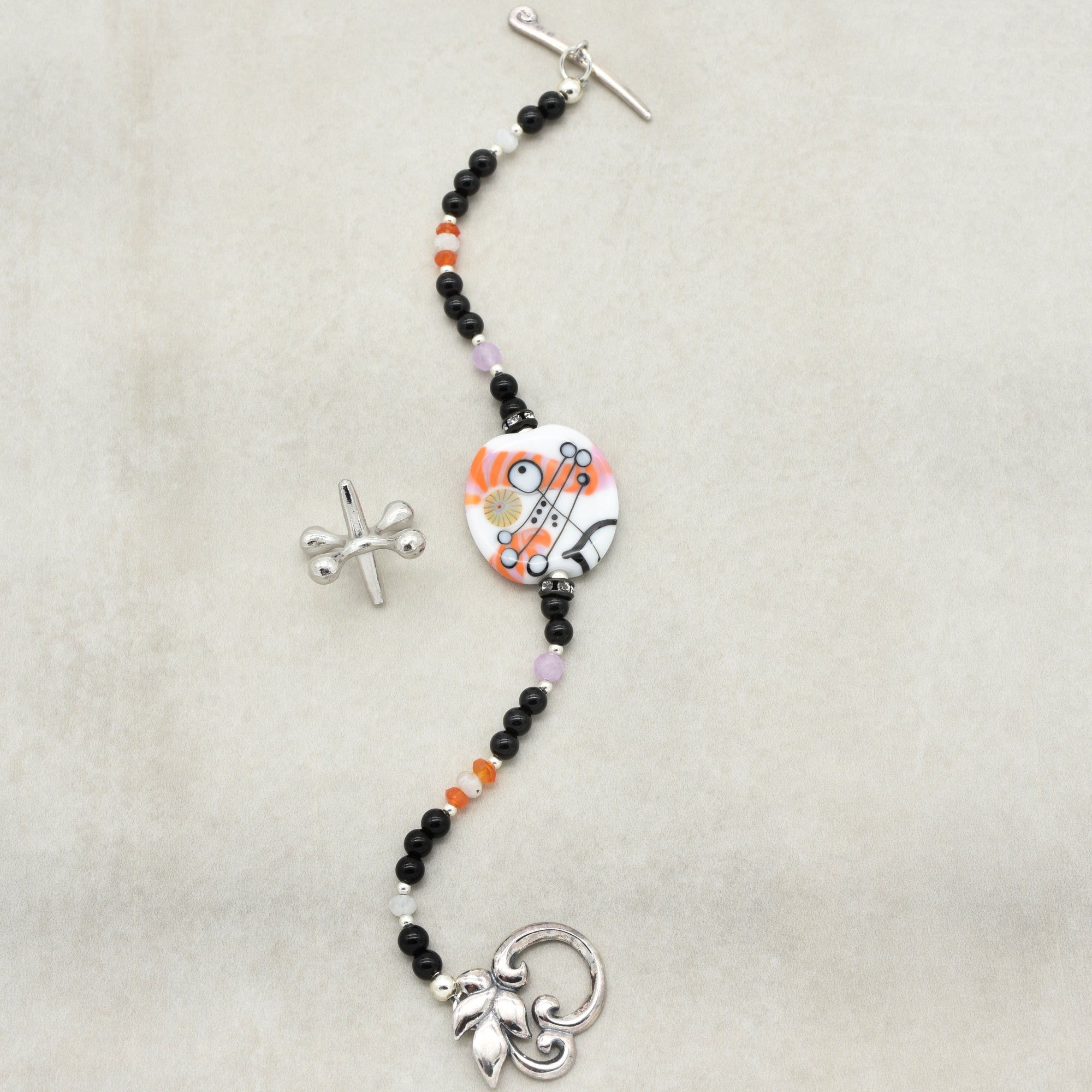 Decorative keychain with beads and charms on a beige background