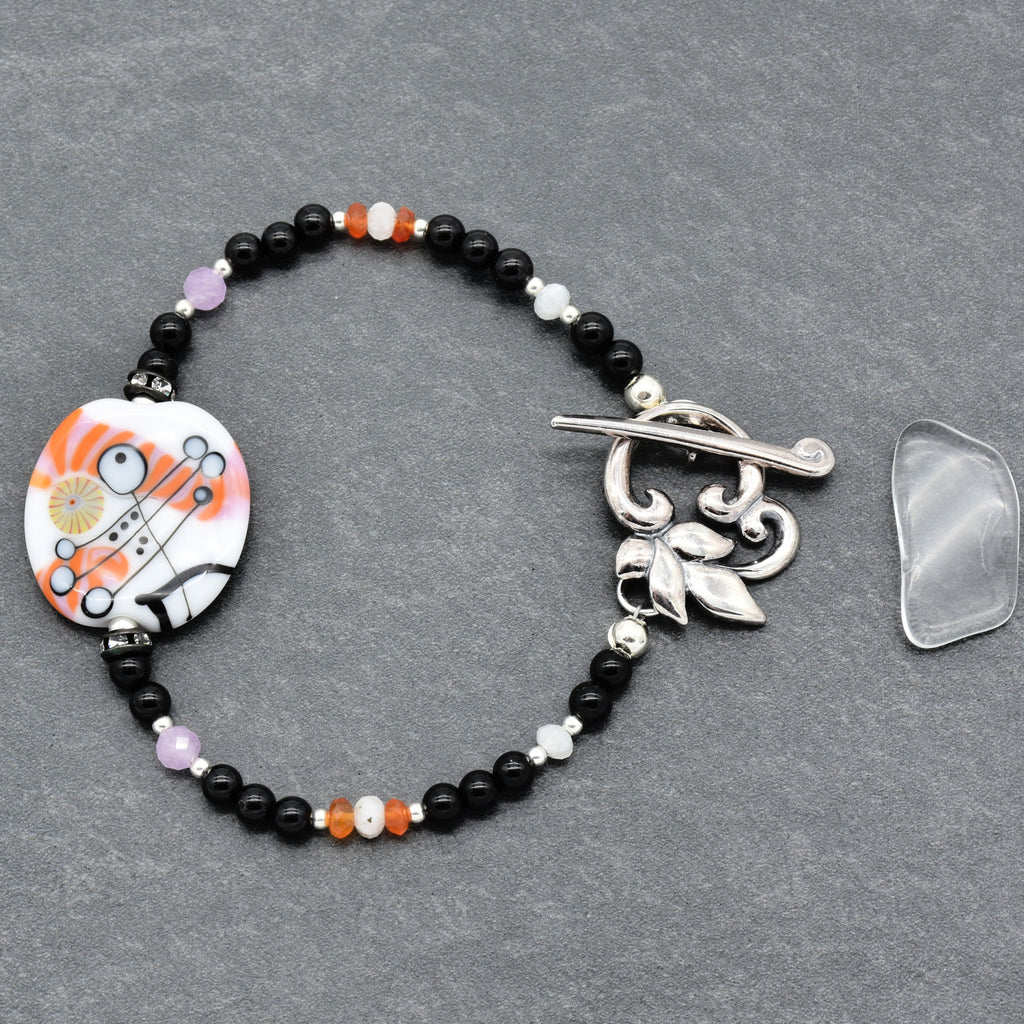 Beaded bracelet with a decorative clasp on a gray surface
