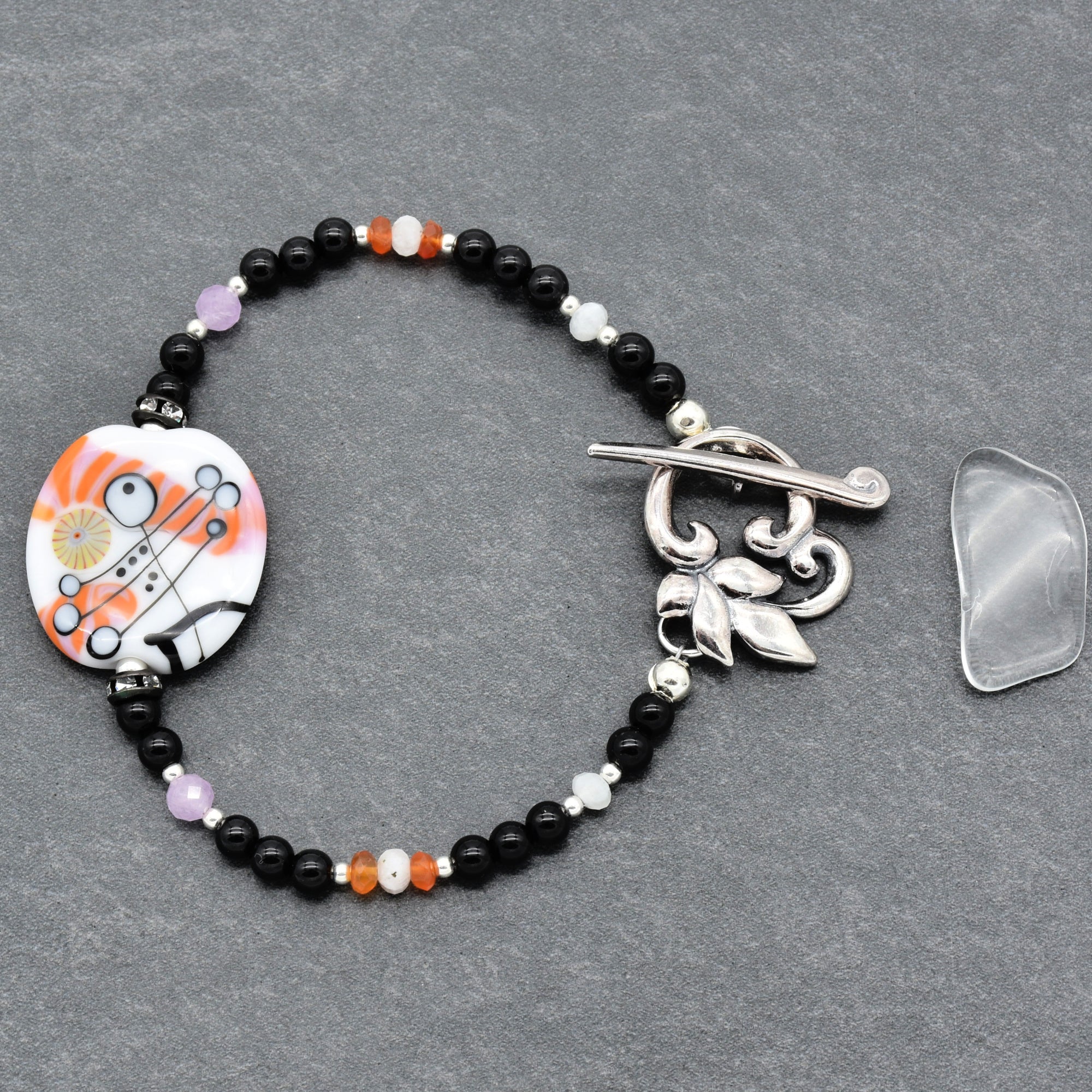 Beaded bracelet with a decorative clasp on a gray surface