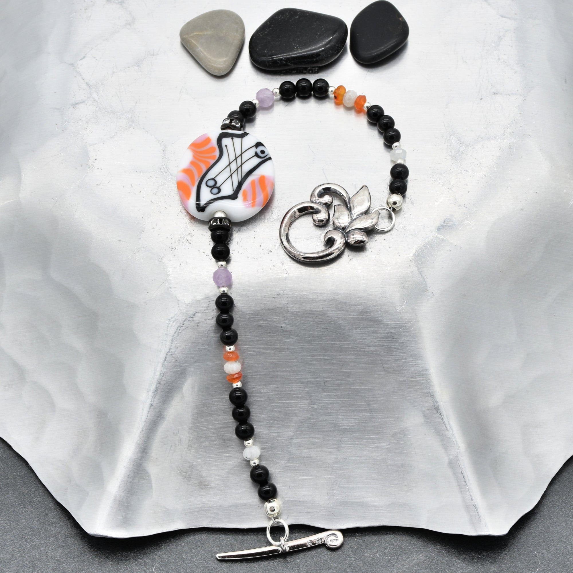 Beaded necklace with decorative elements on a white fabric background