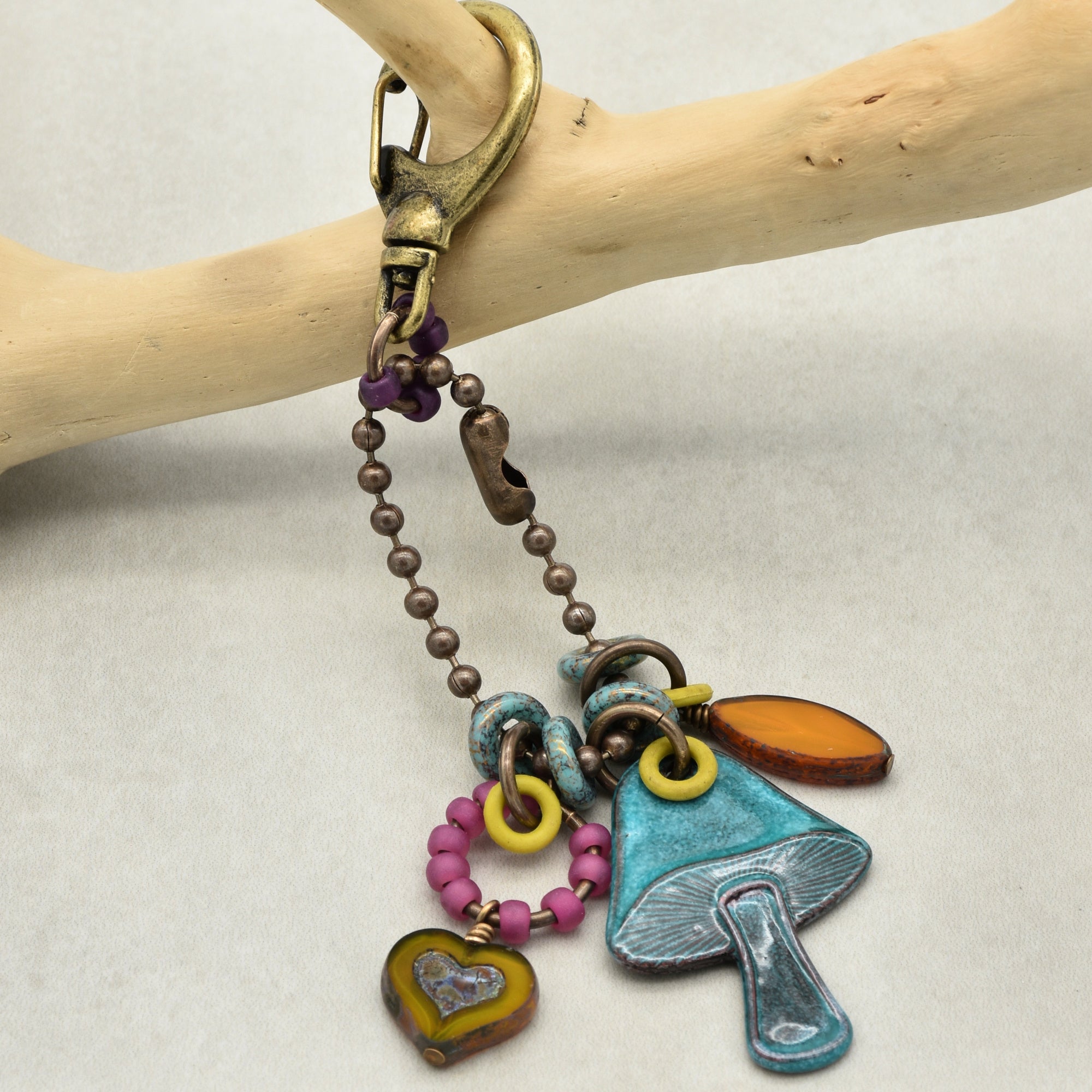 Colorful keychain with charms on a branch against a light background
