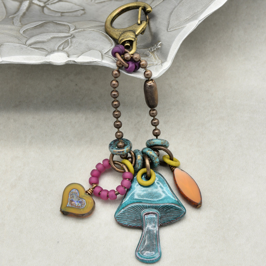 Colorful keychain with mushroom charm on a textured surface