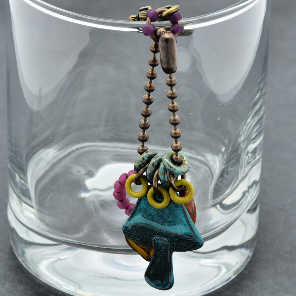 Colorful keychain hanging from a glass container on a gray surface