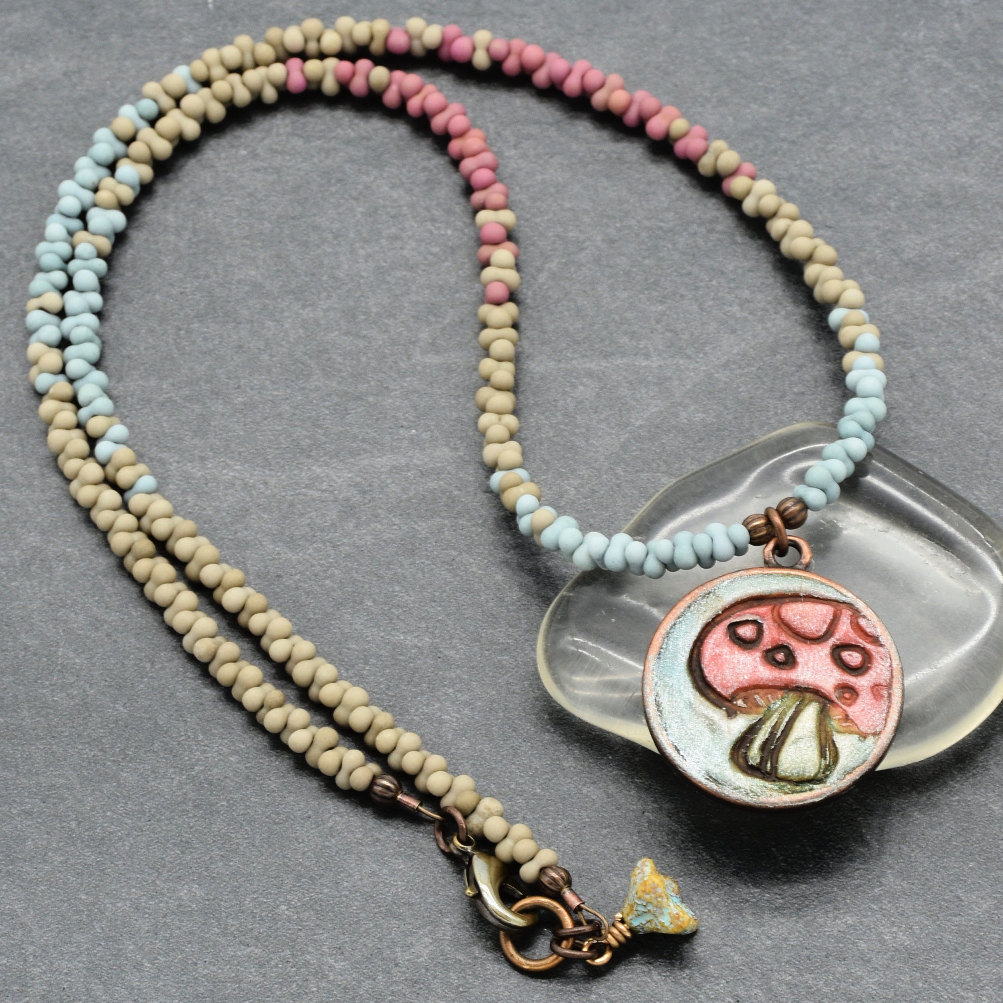 Necklace with a mushroom pendant on a gray background