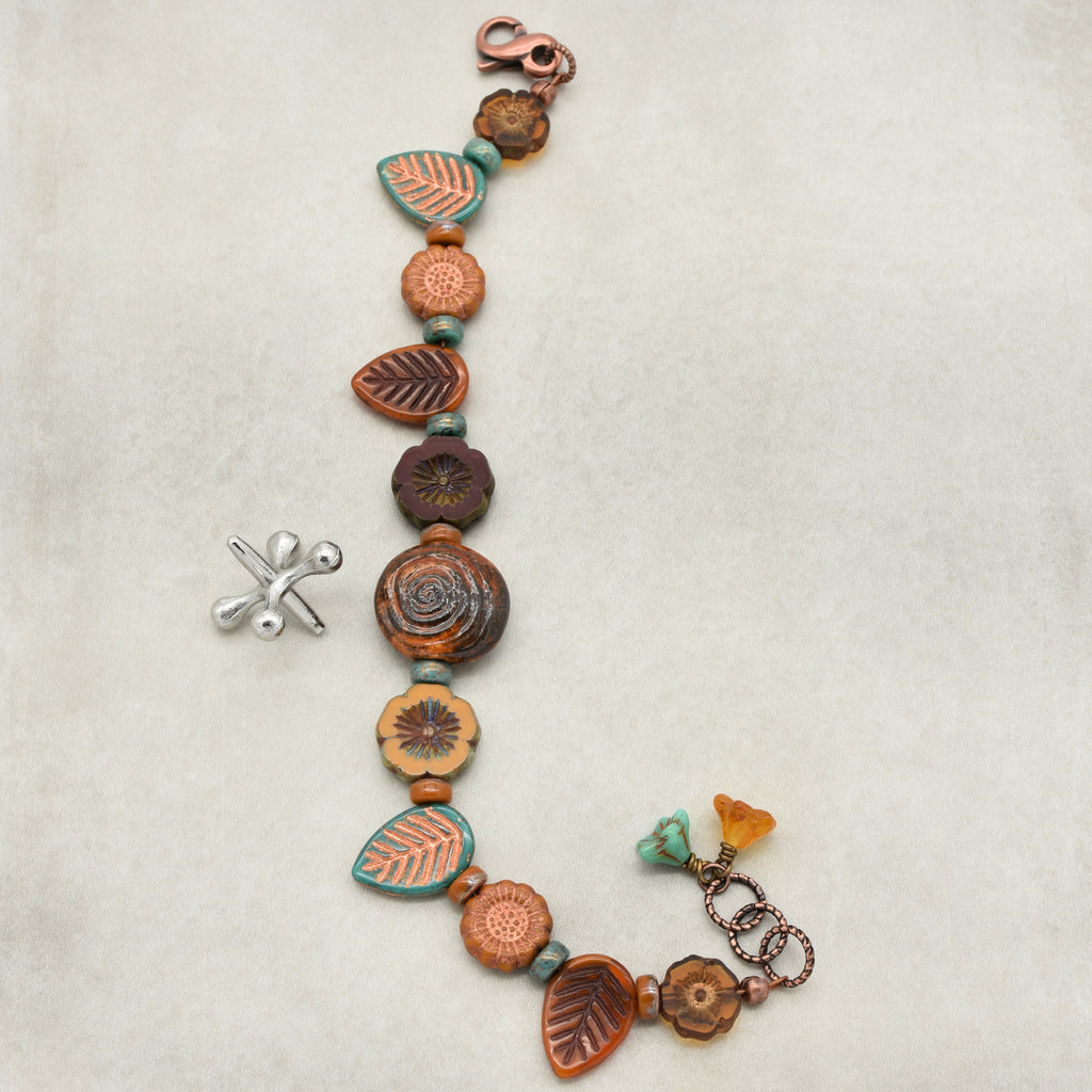 Bracelet with ceramic beads and charms on a light background