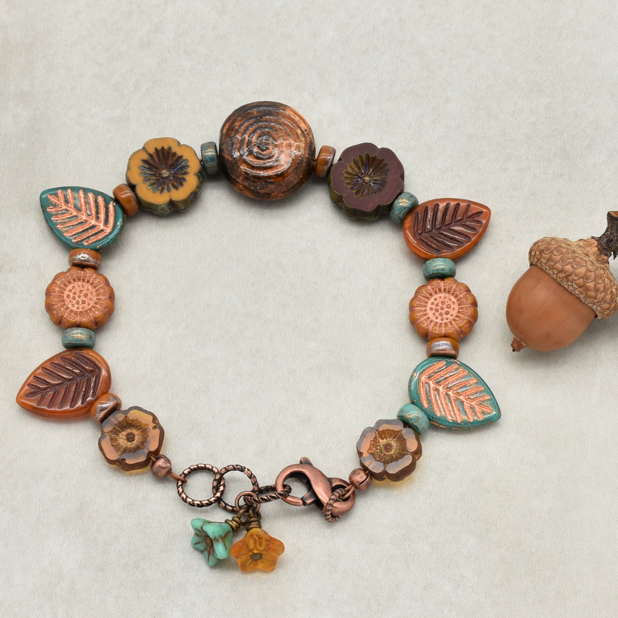 Bracelet with ceramic beads and charms on a textured beige background