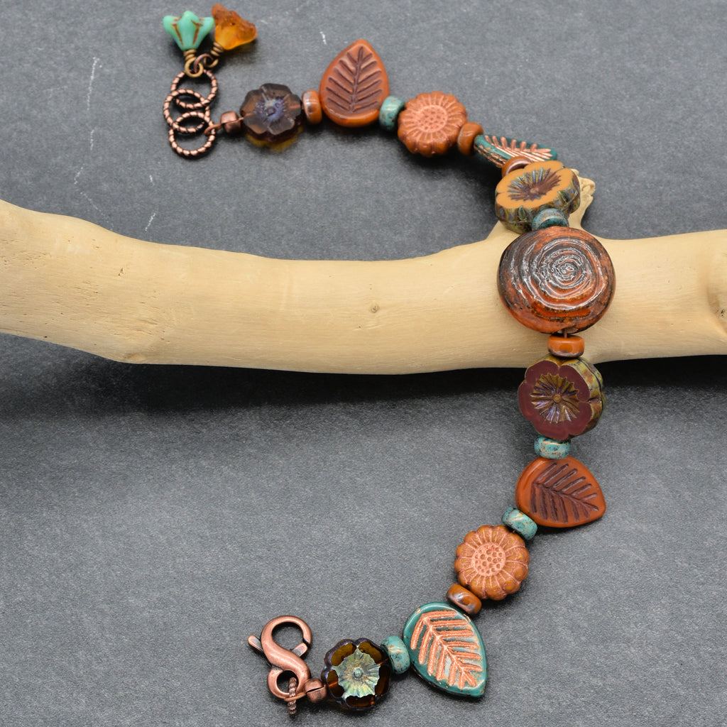 Handmade necklace with ceramic beads and charms on a gray background