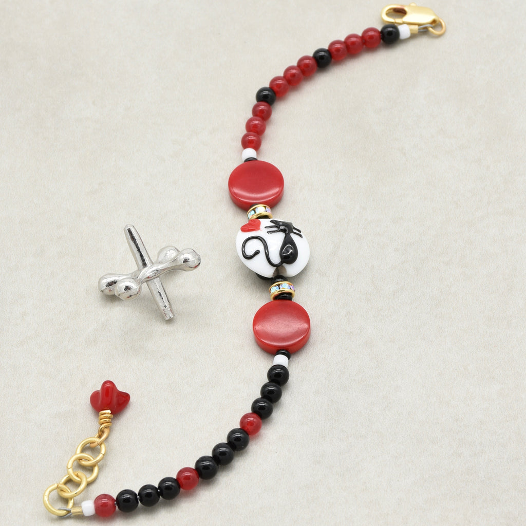 Beaded bracelet with red, black, and white beads on a beige background