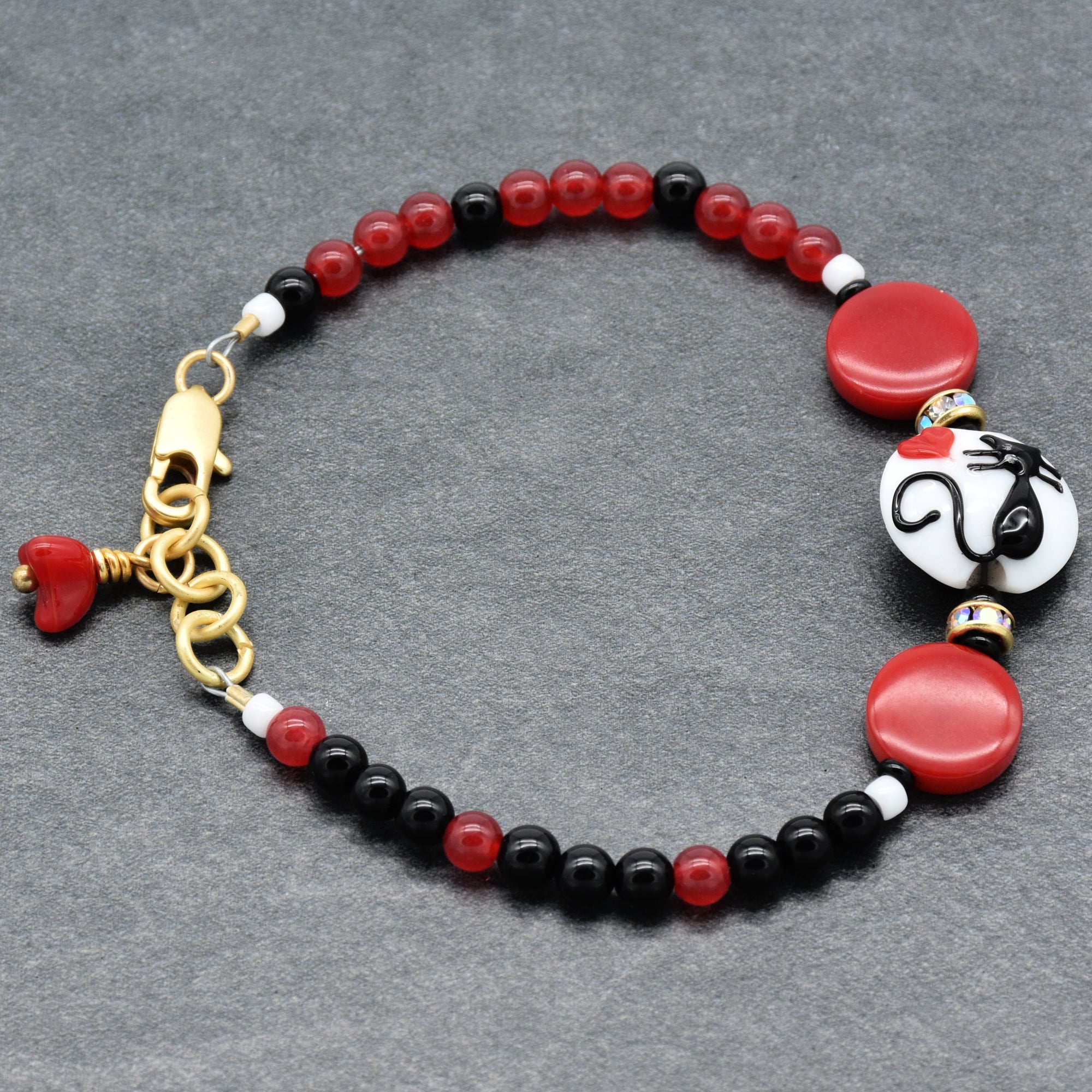 Beaded bracelet with red, black, and white beads on a gray background