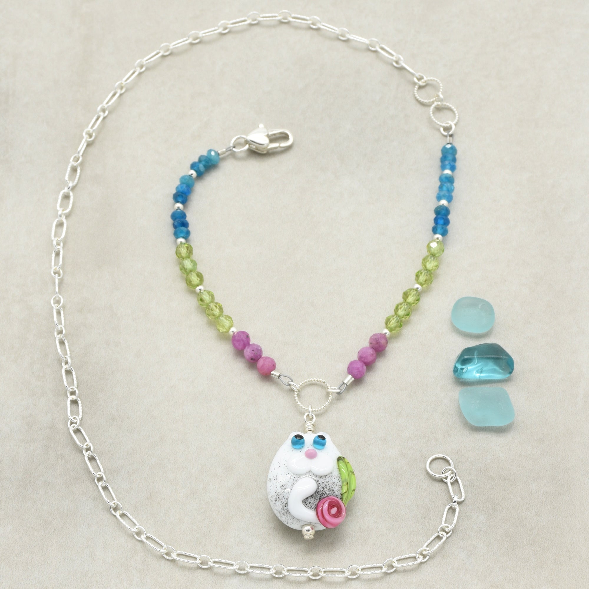 Necklace with colorful beads and a unique pendant on a neutral background
