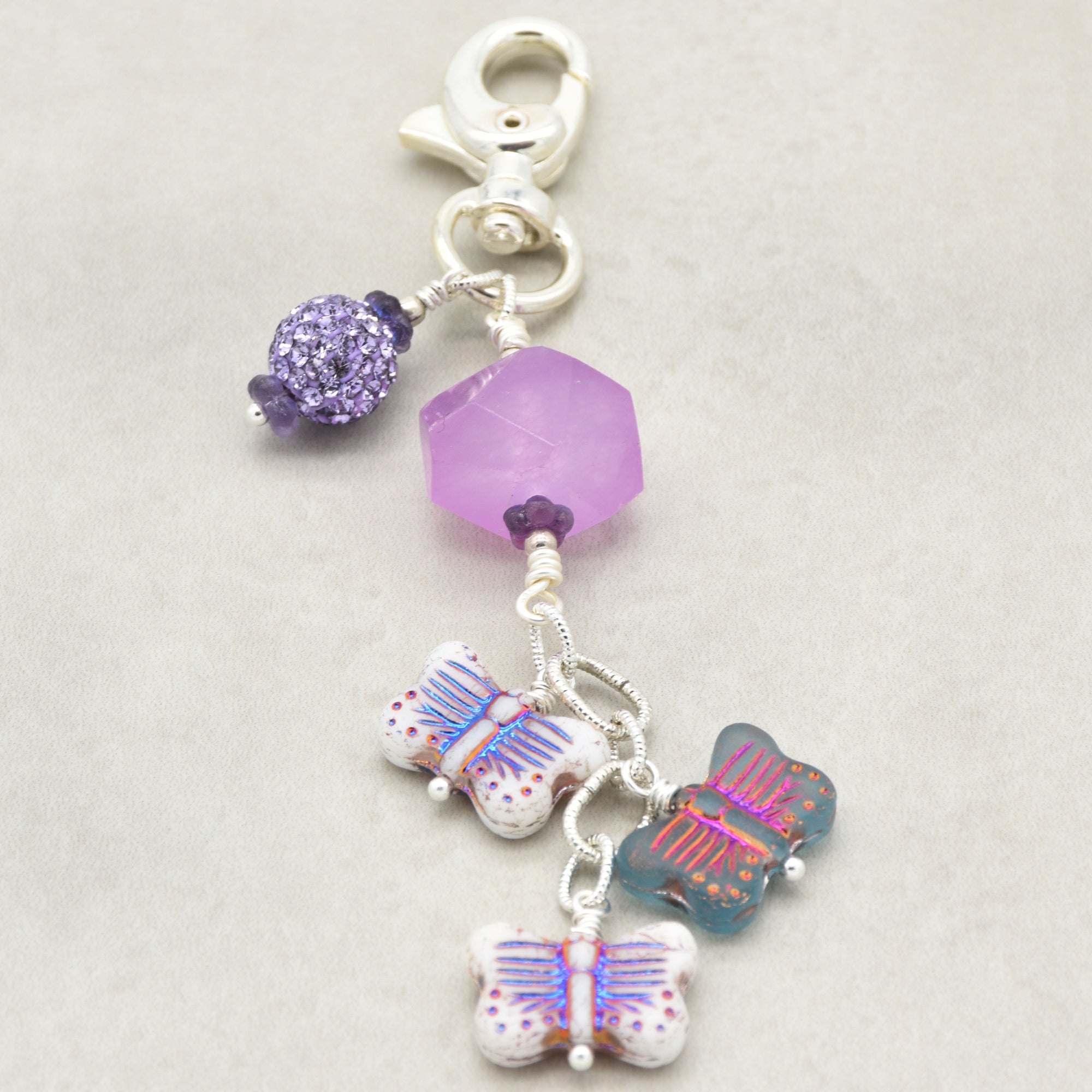 Lilac quartz handbag charm with butterfly charms on a light background - handmade with love by Ruby Acorn