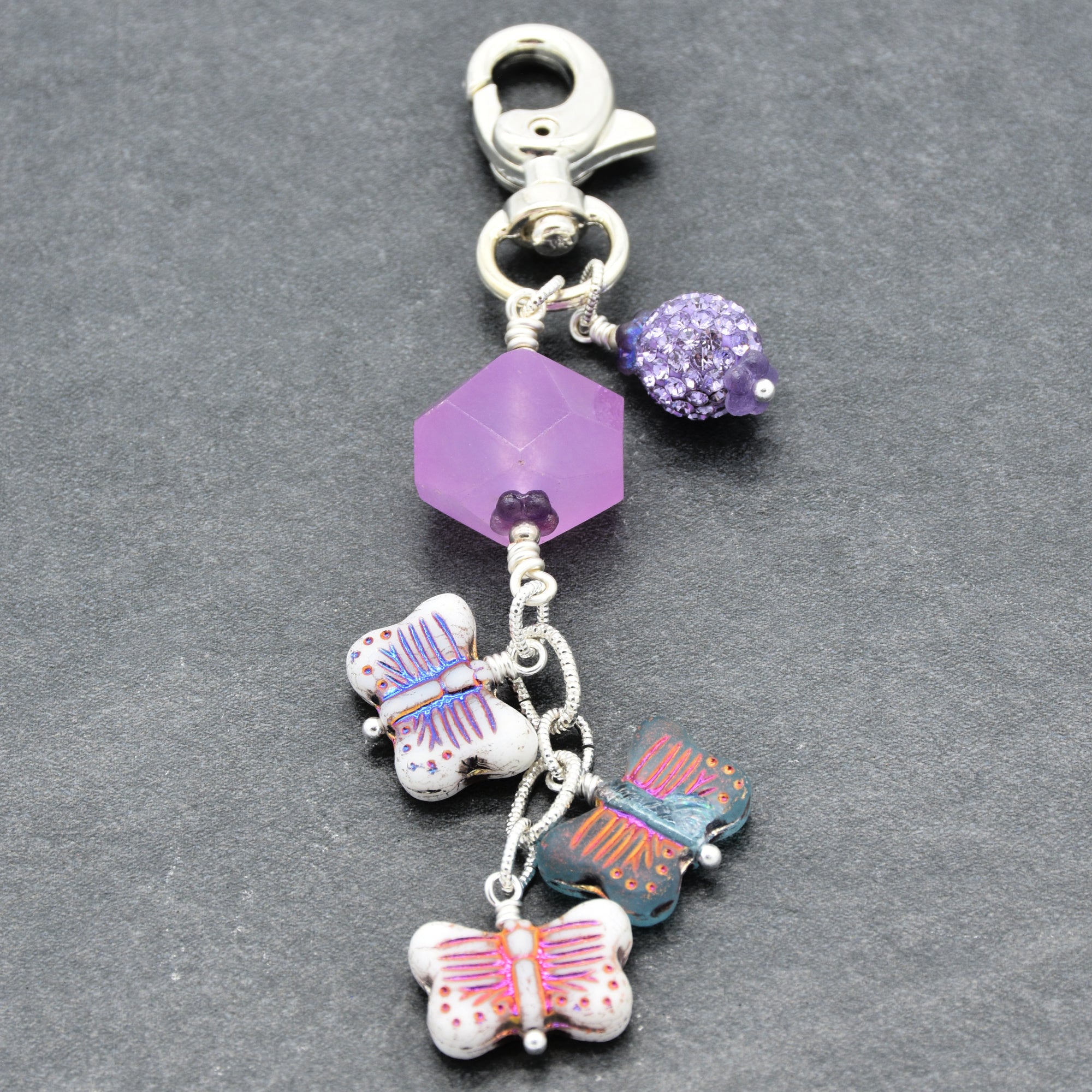 Lilac quartz handbag charm with butterfly charms on a gray background - handmade with love by Ruby Acorn