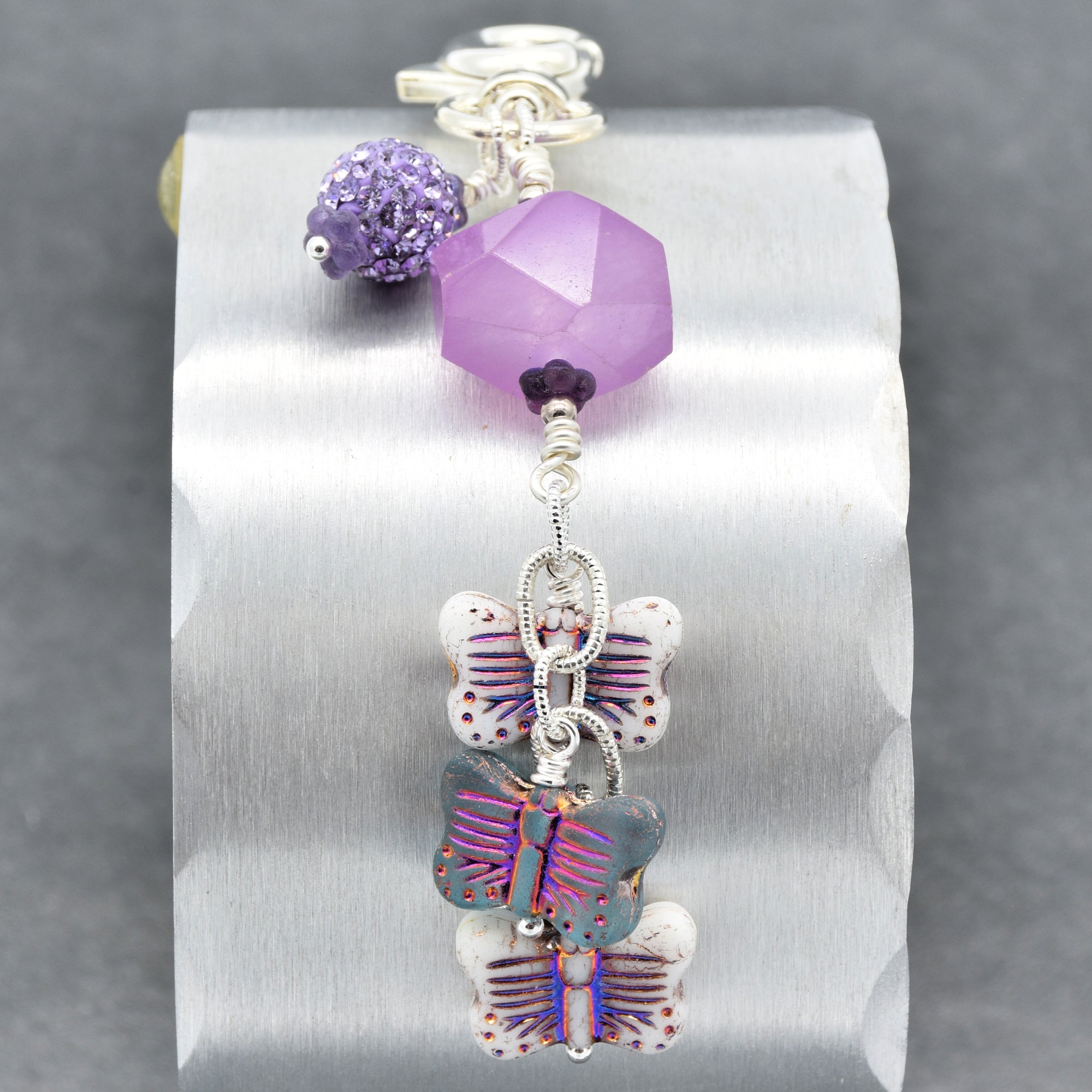 Lilac quartz handbag charm with butterfly charms on a gray background - handmade with love by Ruby Acorn