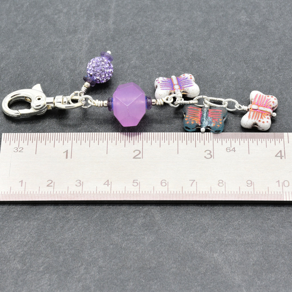 Lilac quartz handbag charm with butterfly charms next to a ruler for scale - handmade with love by Ruby Acorn