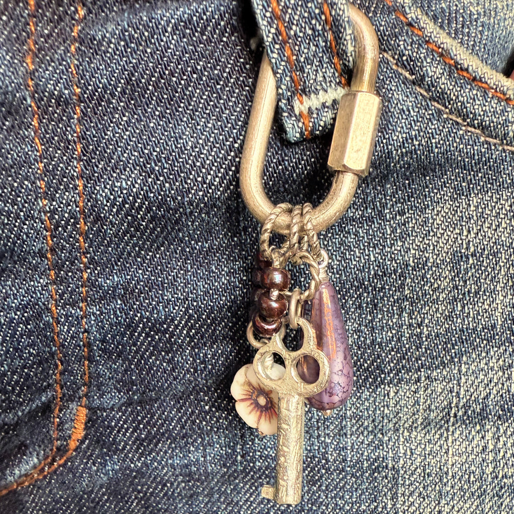 Decorative keychain with charms attached to a denim fabric background