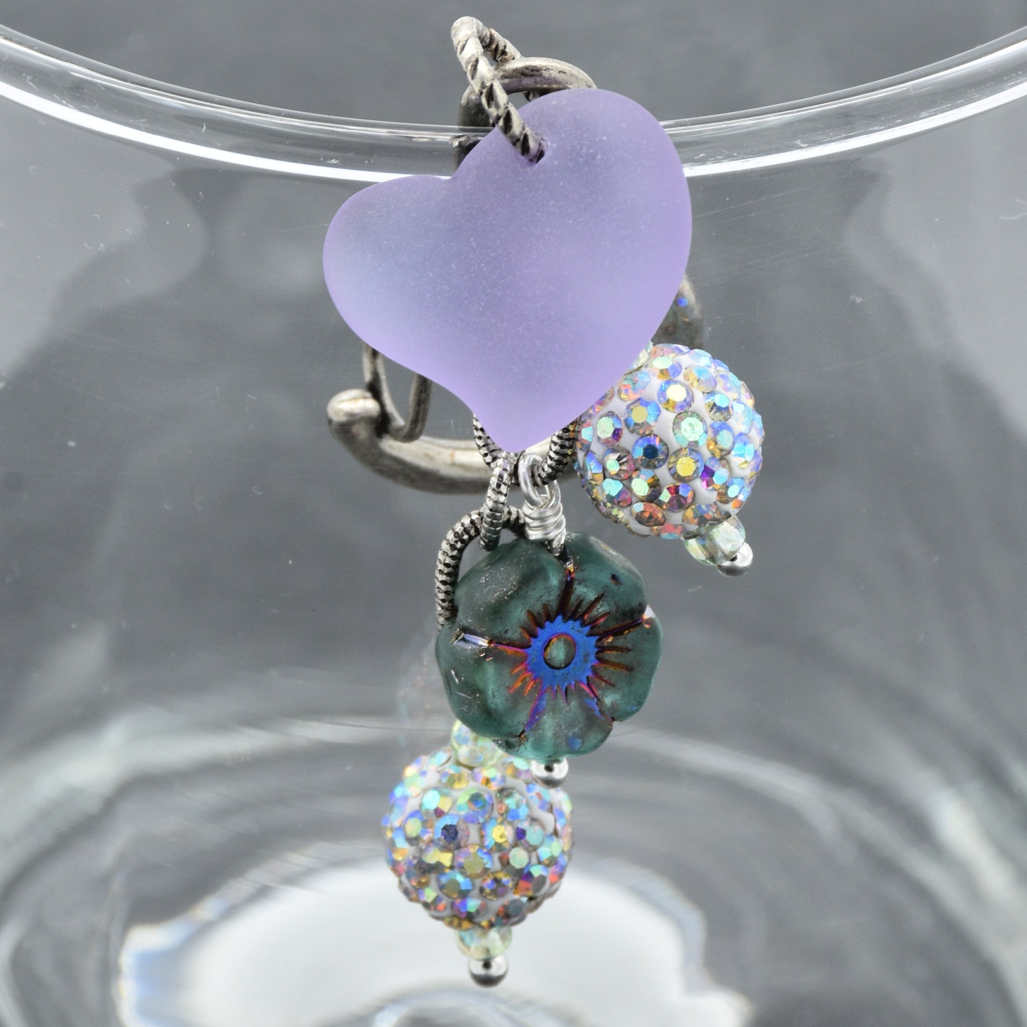 Silver keychain with heart-shaped and multicolored bead charms on a clear stand.