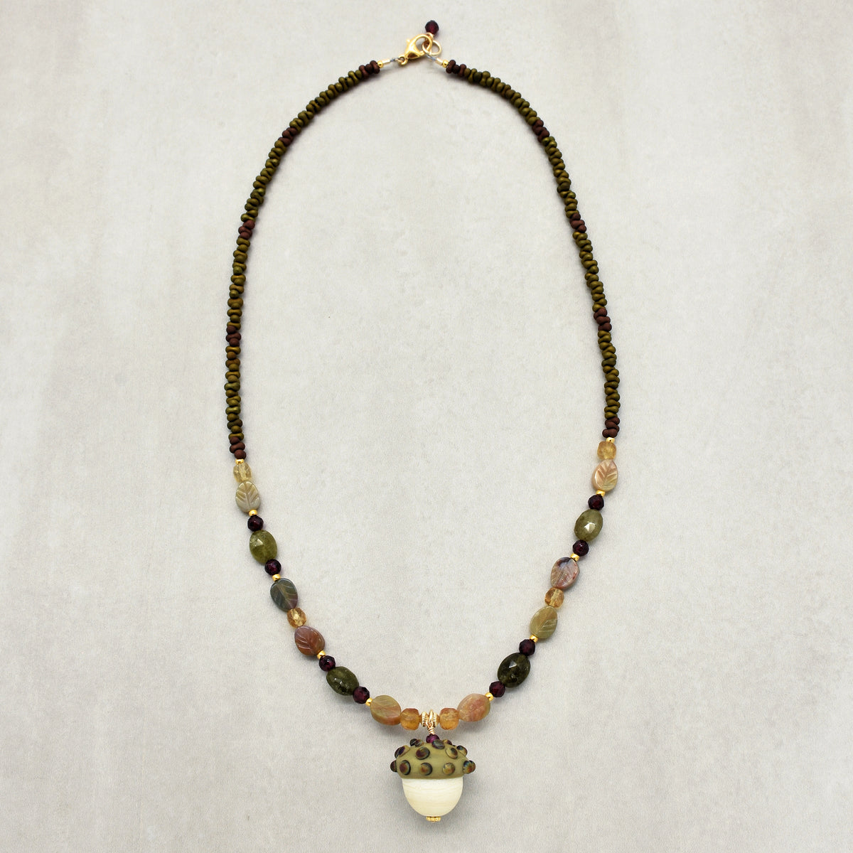 Forest Fable Necklace featuring artisan lampwork glass acorn focal with green garnet, red garnet and citrine, handmade by Ruby Acorn