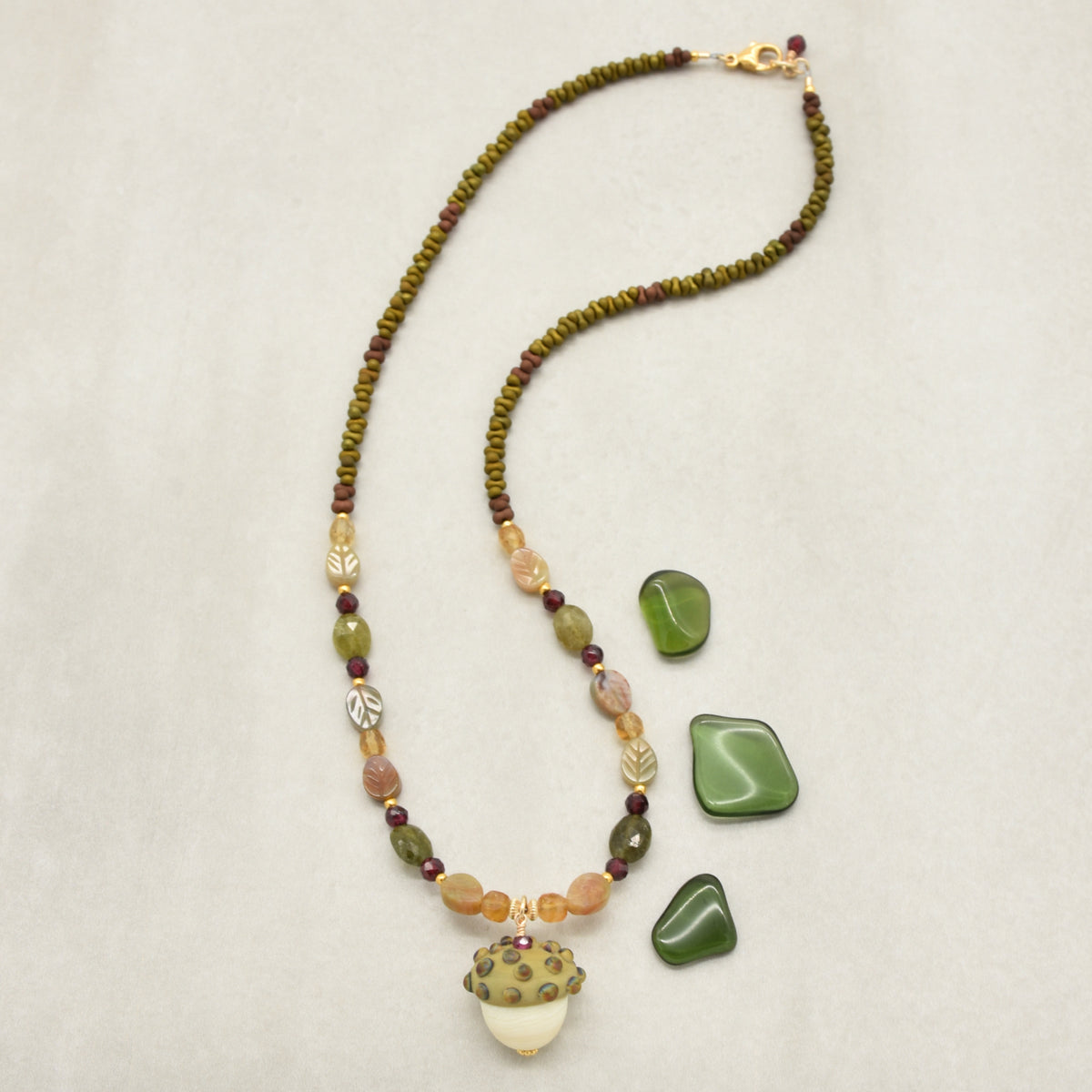 Forest Fable Necklace featuring artisan lampwork glass acorn focal with green garnet, red garnet and citrine, handmade by Ruby Acorn