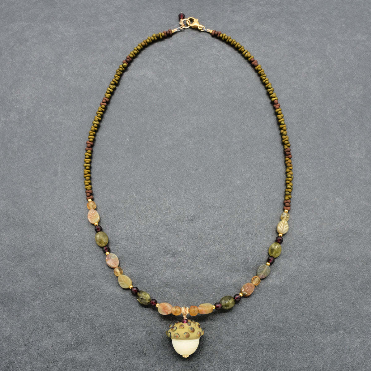 Forest Fable Necklace featuring artisan lampwork glass acorn focal with green garnet, red garnet and citrine, handmade by Ruby Acorn