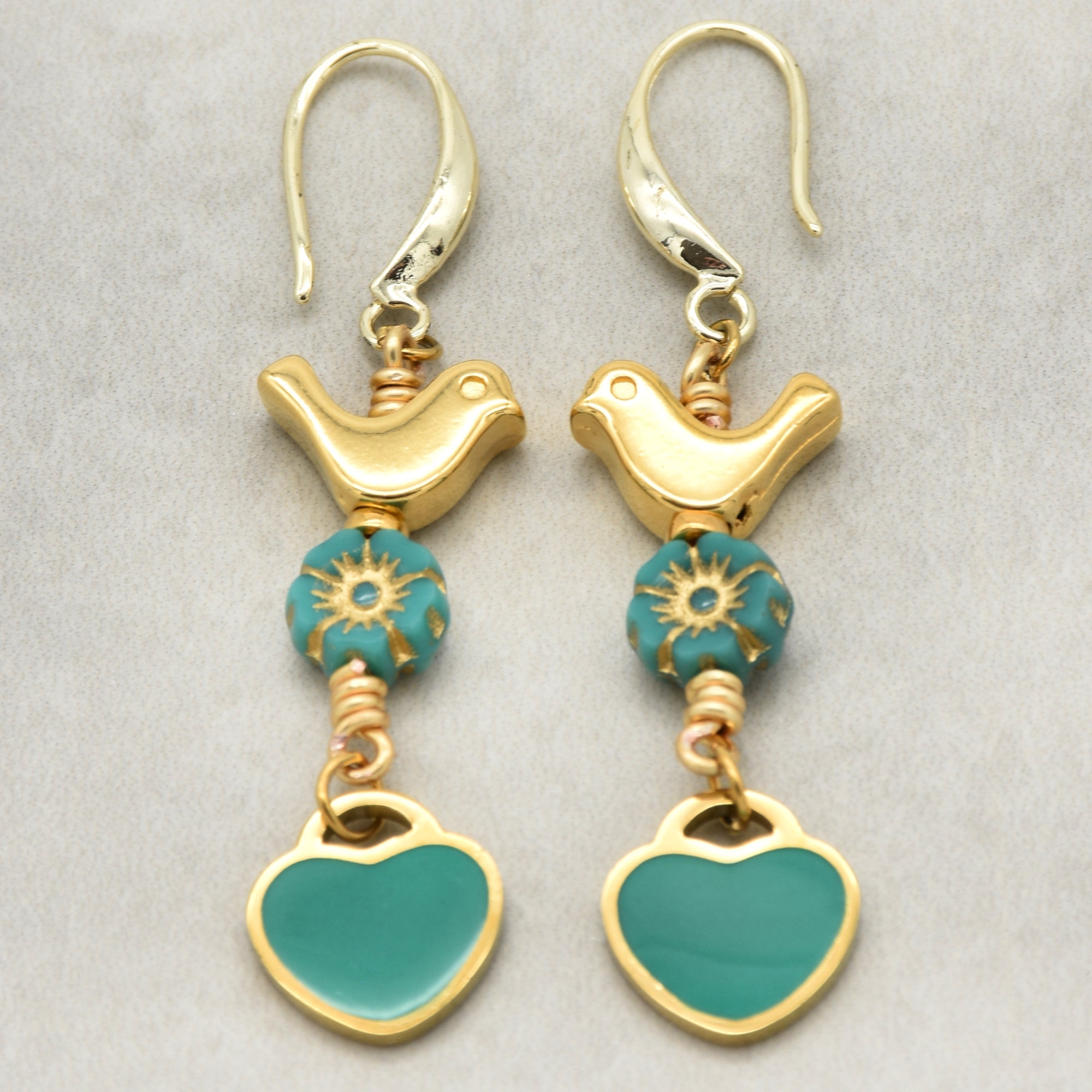 Lovebirds Turquoise Blue dangle earrings with gold birds and heart charms on a light background - handmade with love by Ruby Acorn