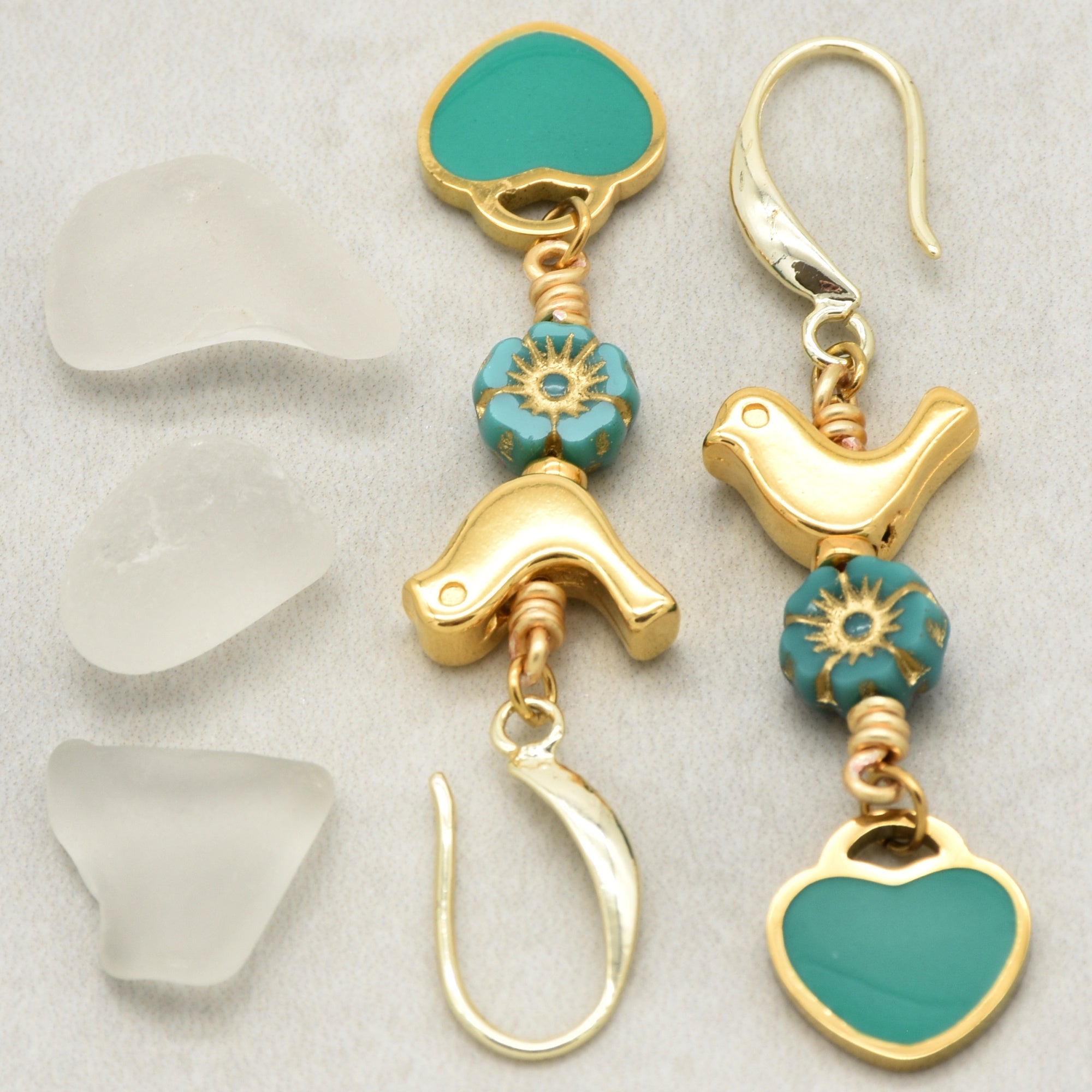 Lovebirds Turquoise Blue dangle earrings with gold birds and heart charms on a light background - handmade with love by Ruby Acorn
