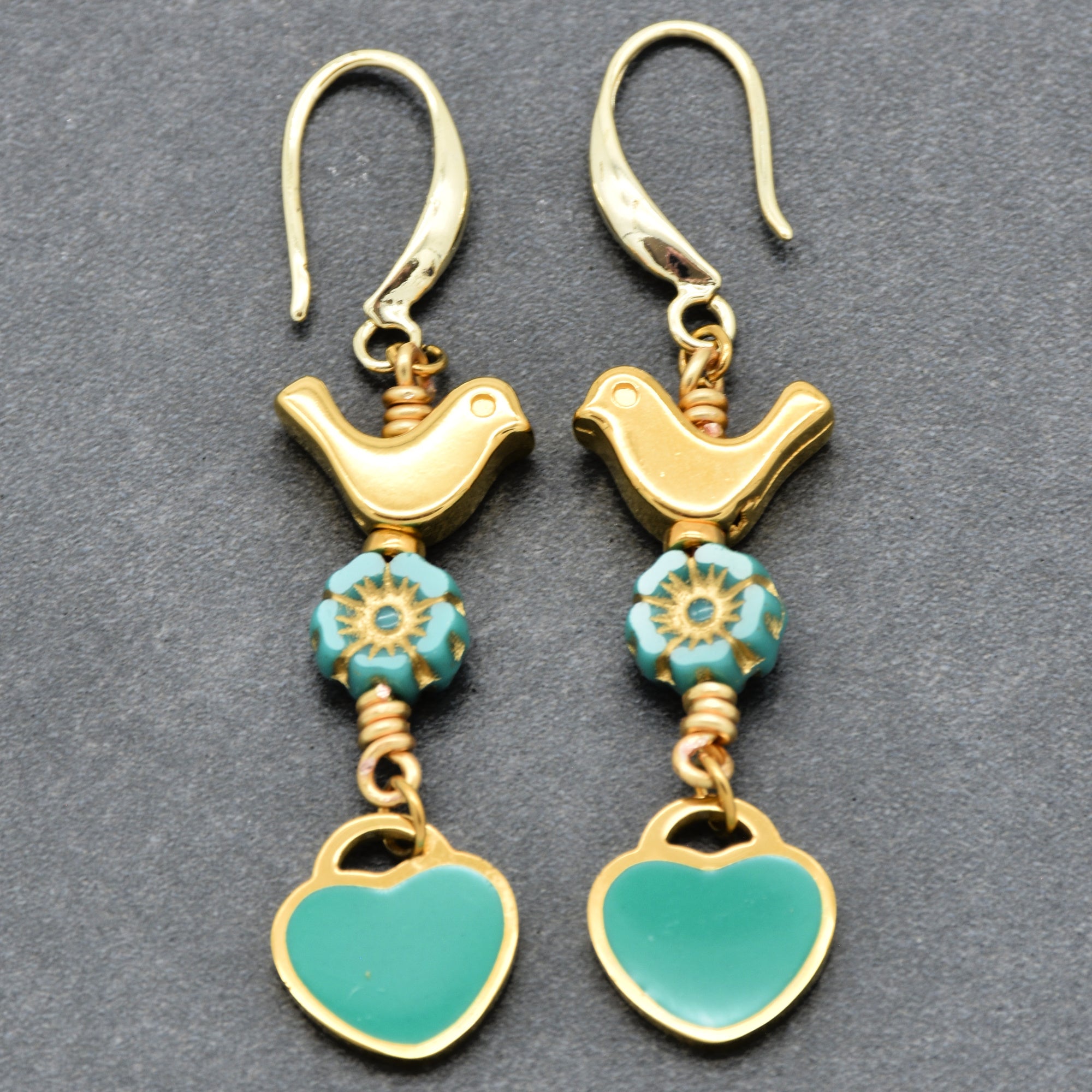 Lovebirds Turquoise Blue dangle earrings with gold birds and heart charms on a gray background - handmade with love by Ruby Acorn