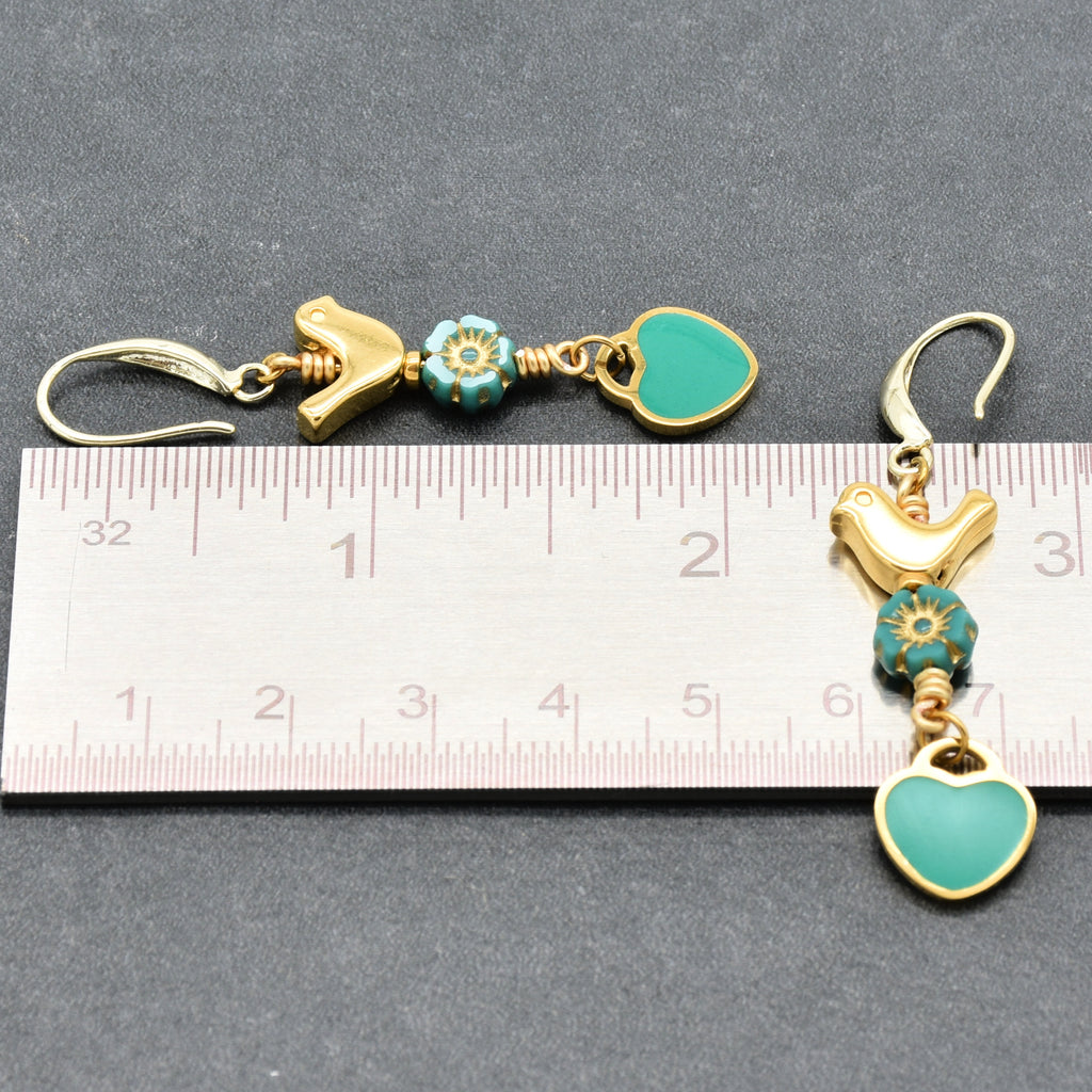 Lovebirds Turquoise Blue dangle earrings with gold birds and heart charms next to a ruler for scale - handmade with love by Ruby Acorn