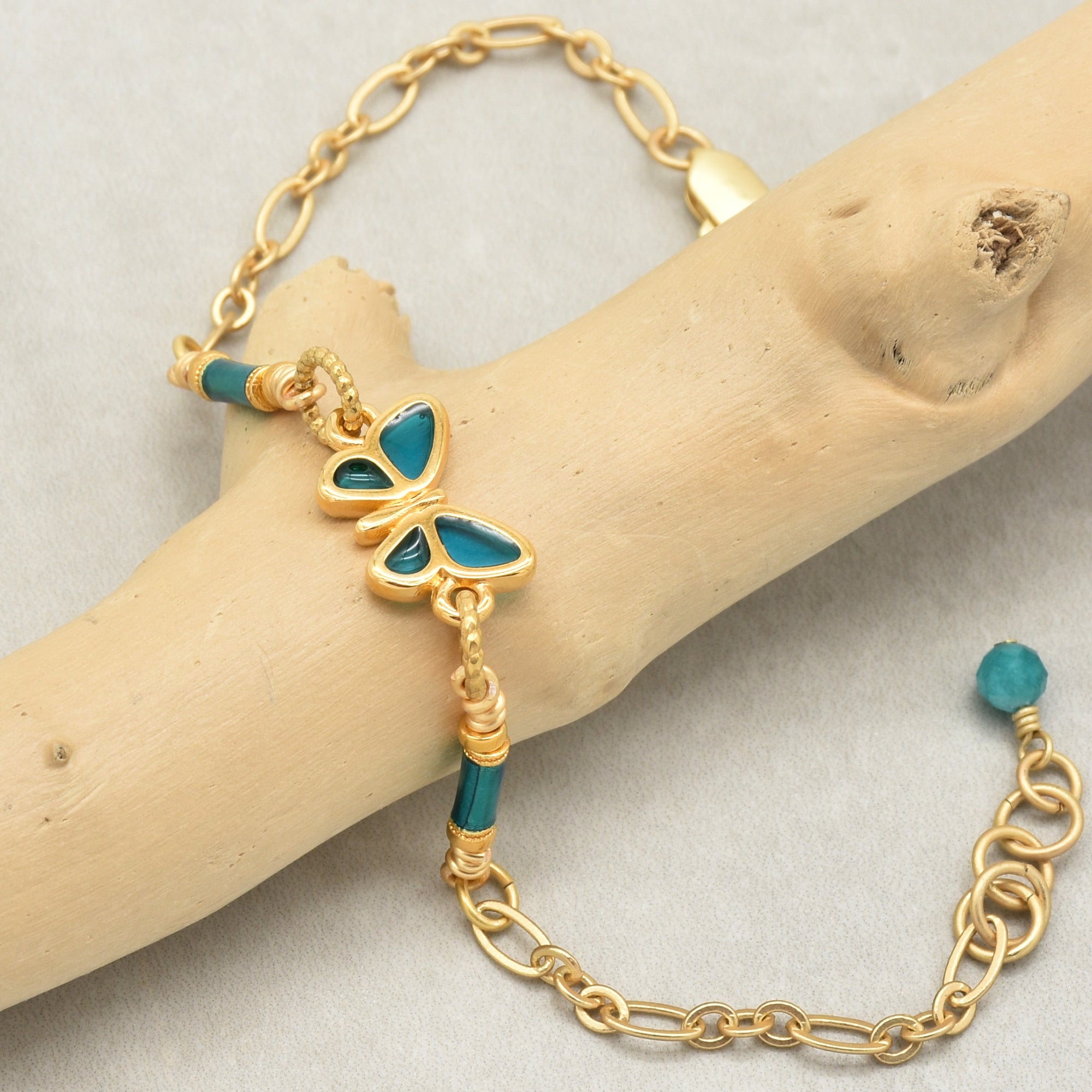 Gold bracelet with blue butterfly charm on a wooden branch - made with love in Colorado by Ruby Acorn