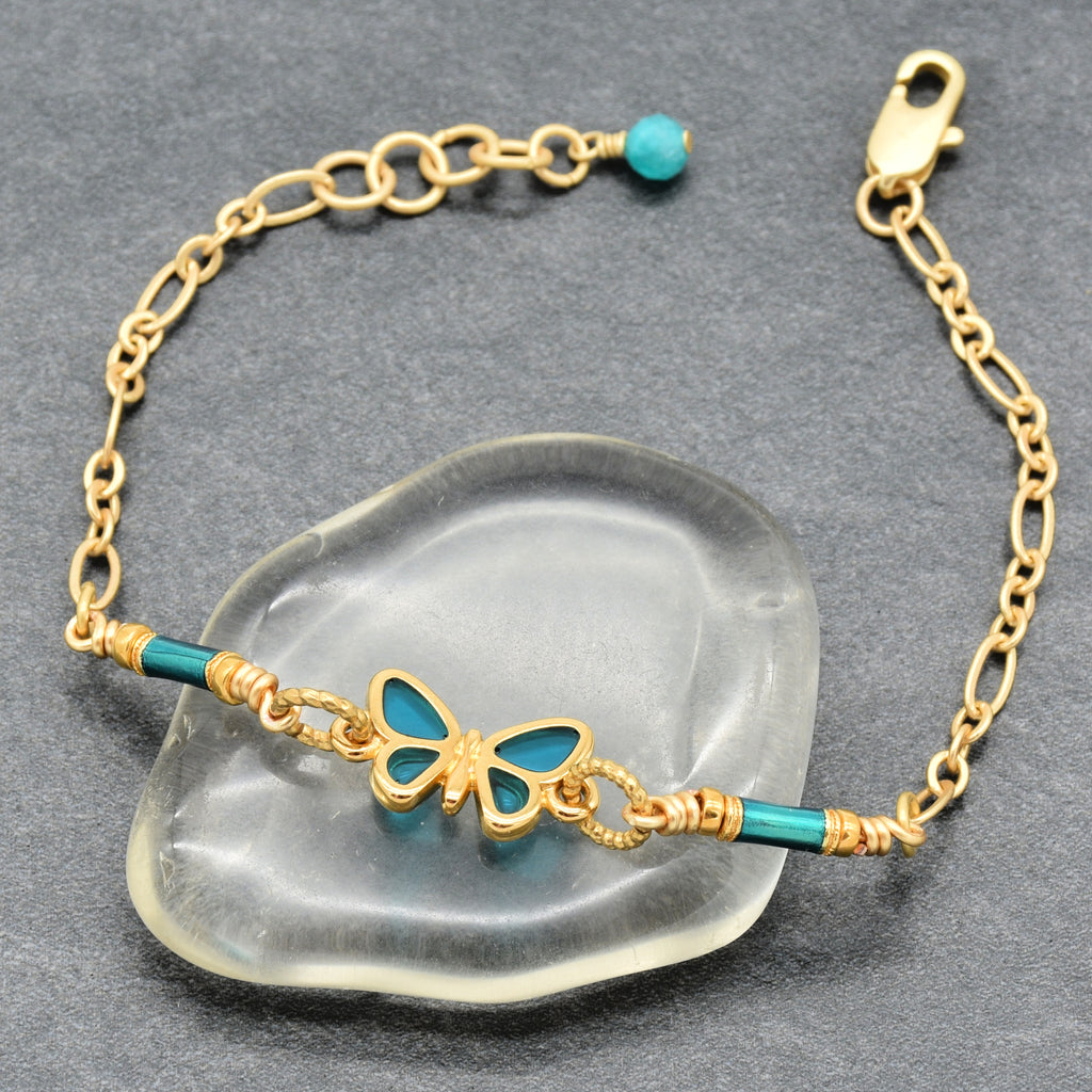 Gold bracelet with turquoise accents on a clear stone surface - art you can wear by Ruby Acorn