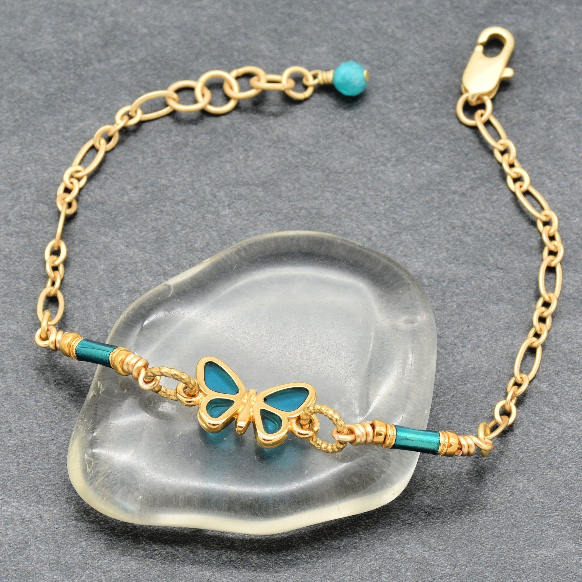 Gold bracelet with turquoise accents on a clear stone surface - art you can wear by Ruby Acorn