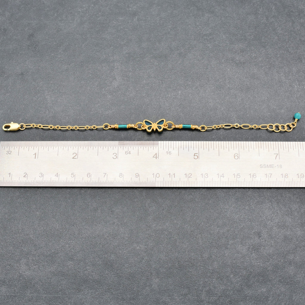 Gold bracelet with blue beads on a gray surface next to a ruler for size reference - Ruby Acorn one of a kind wearable art