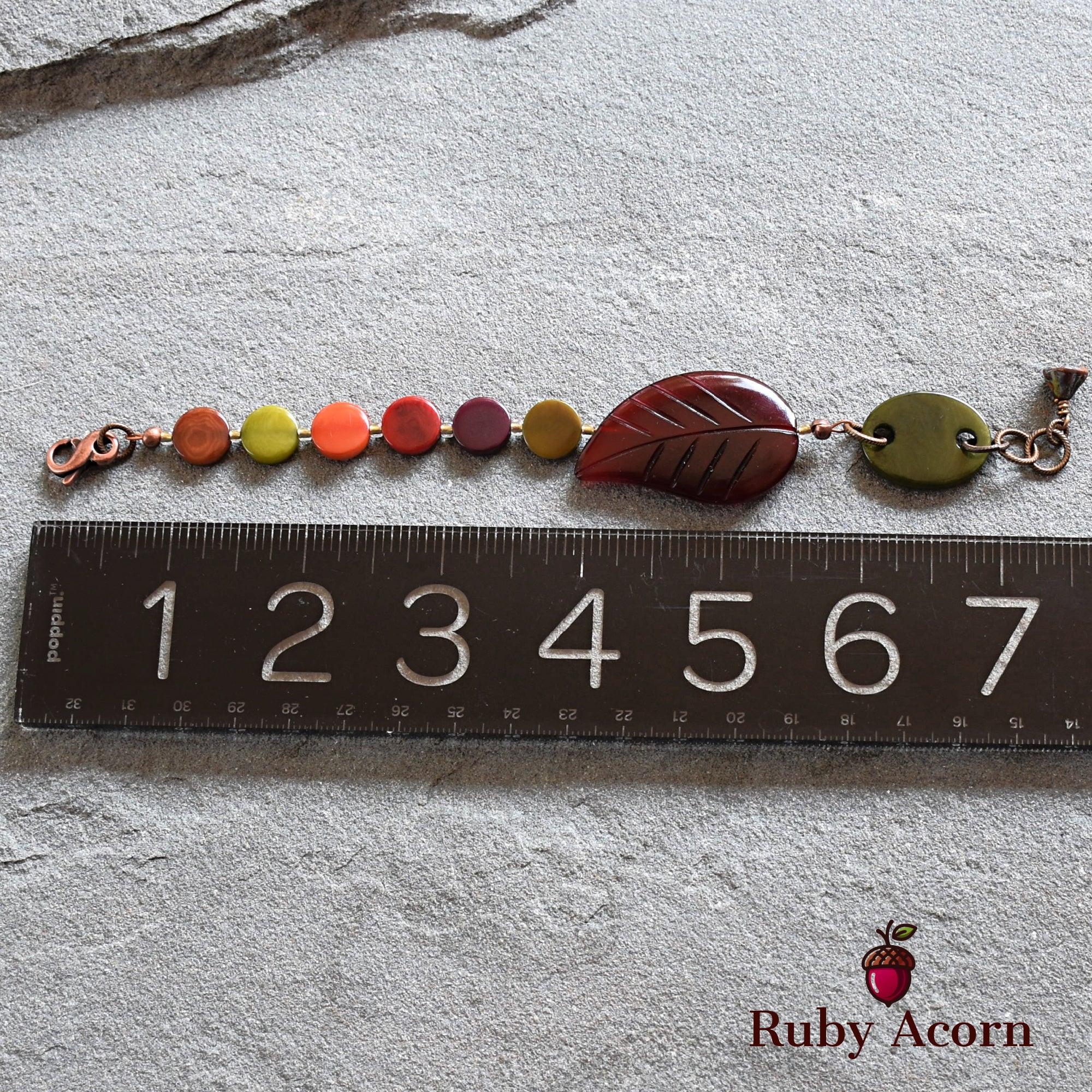 The piece of jewelry in the image is a bracelet. The size and clasp style, along with its length shown next to the ruler, indicate it is a bracelet rather than a necklace or earring.