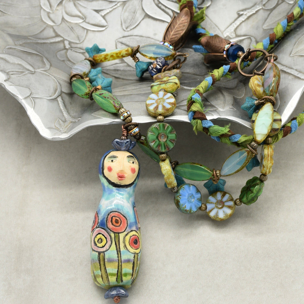 Colorful beaded necklace with a decorative pendant on a textured surface