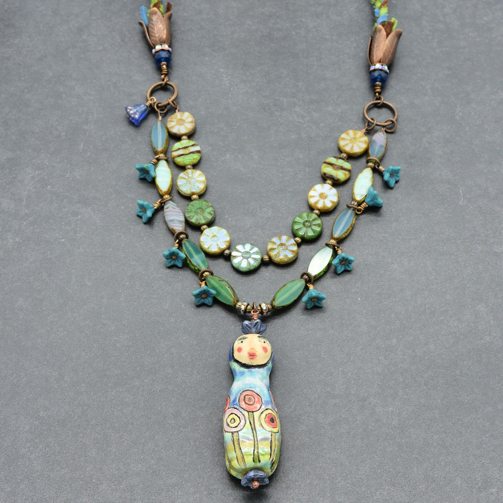 Colorful beaded necklace with a unique pendant on a gray background
