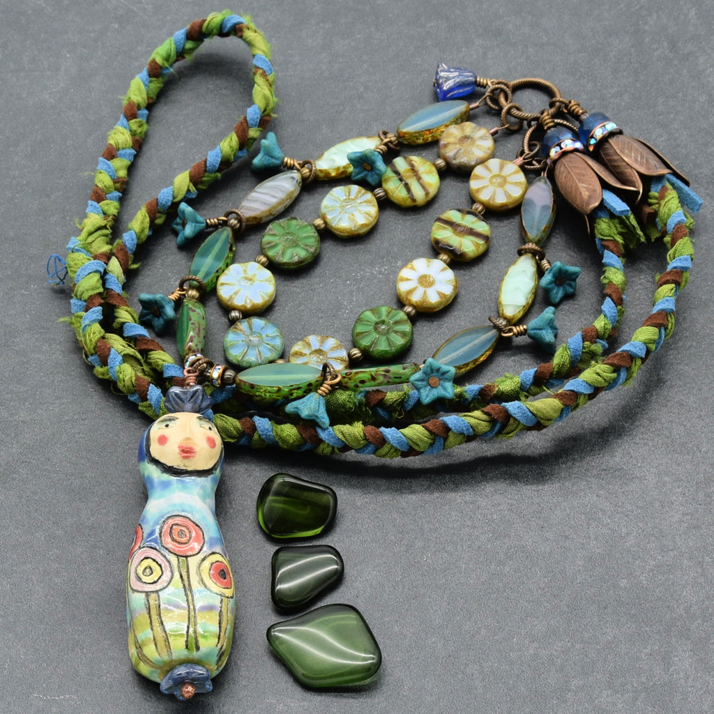 Colorful beaded necklace with a decorative pendant on a gray background