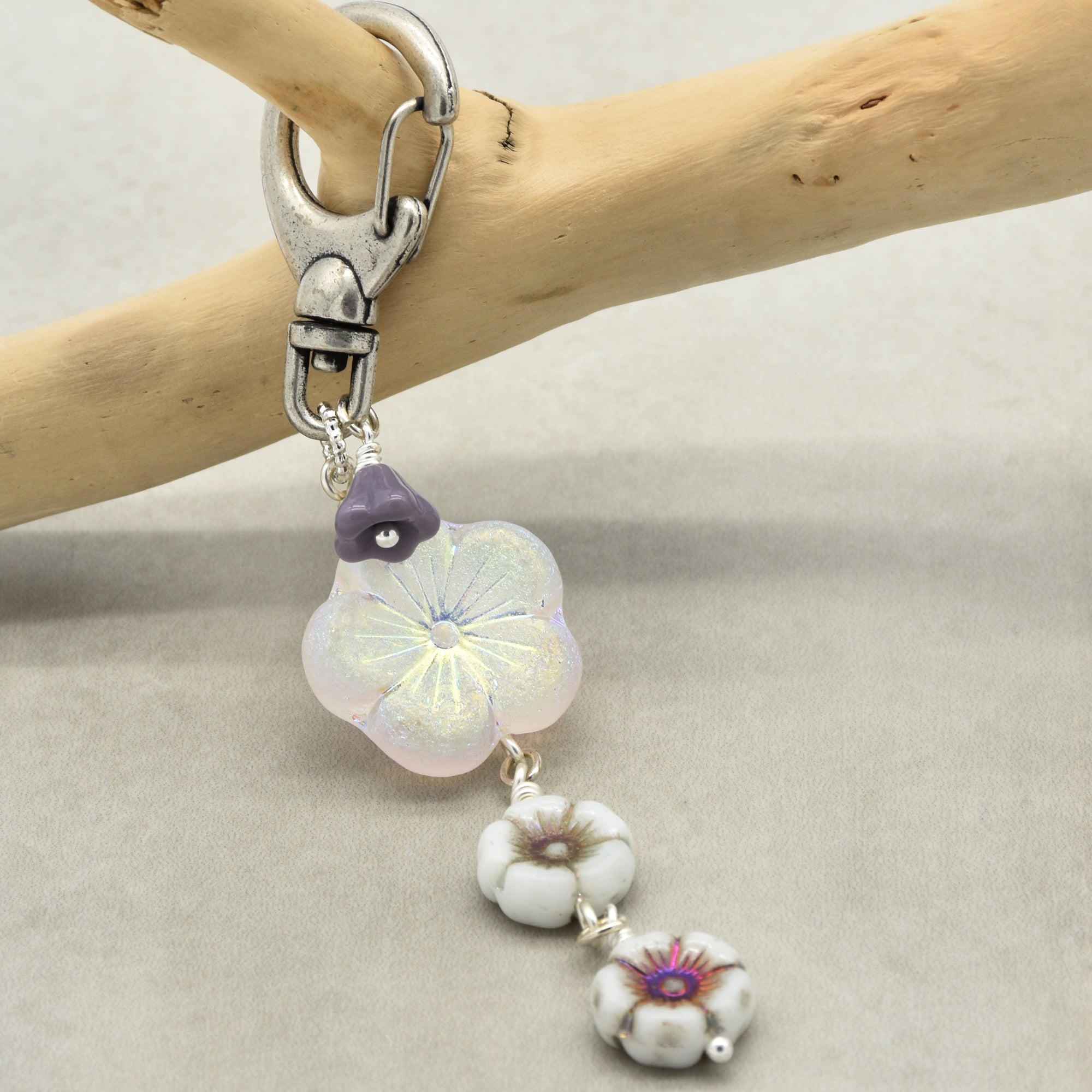 Decorative keychain with floral beads on a wooden branch