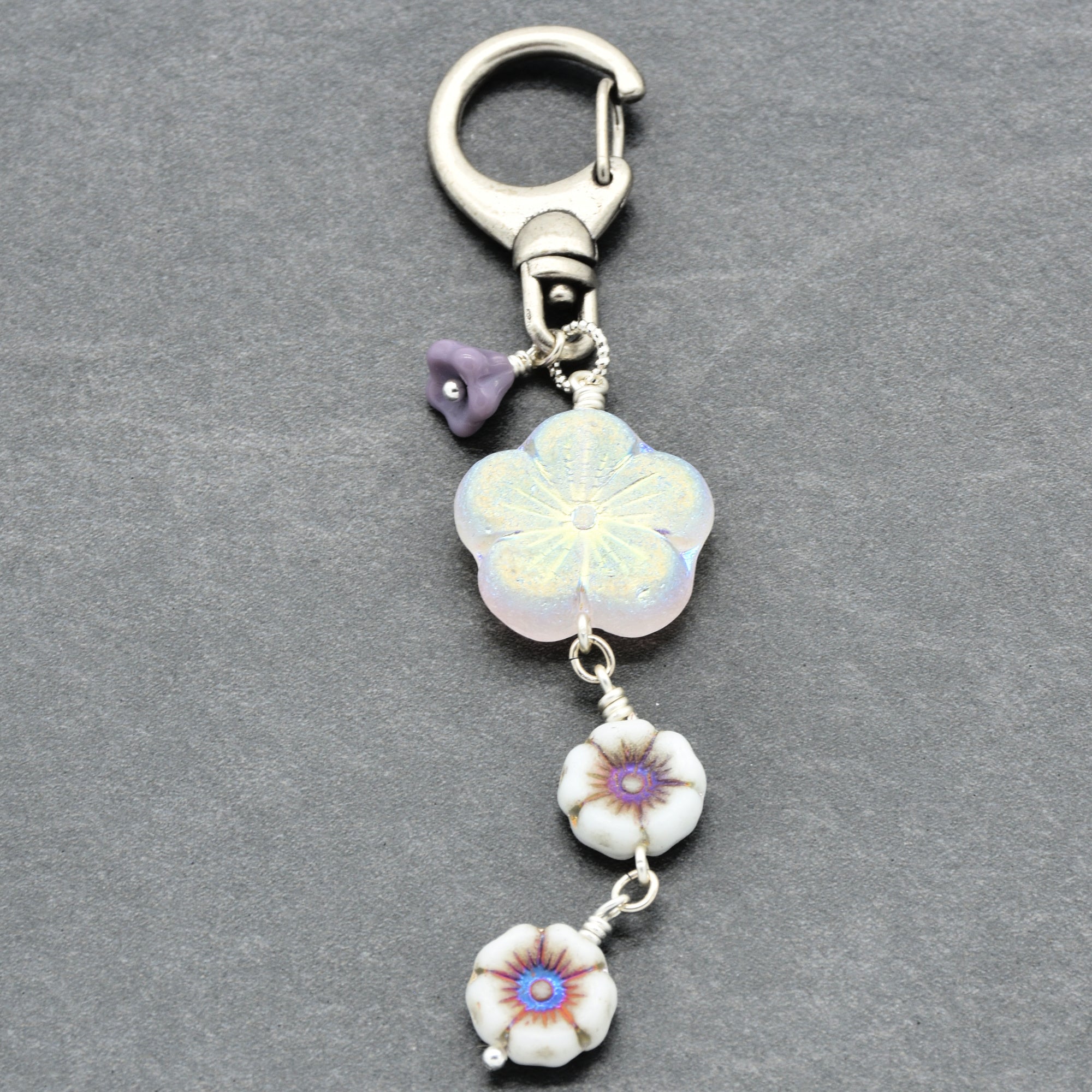 Keychain with floral charms on a gray background
