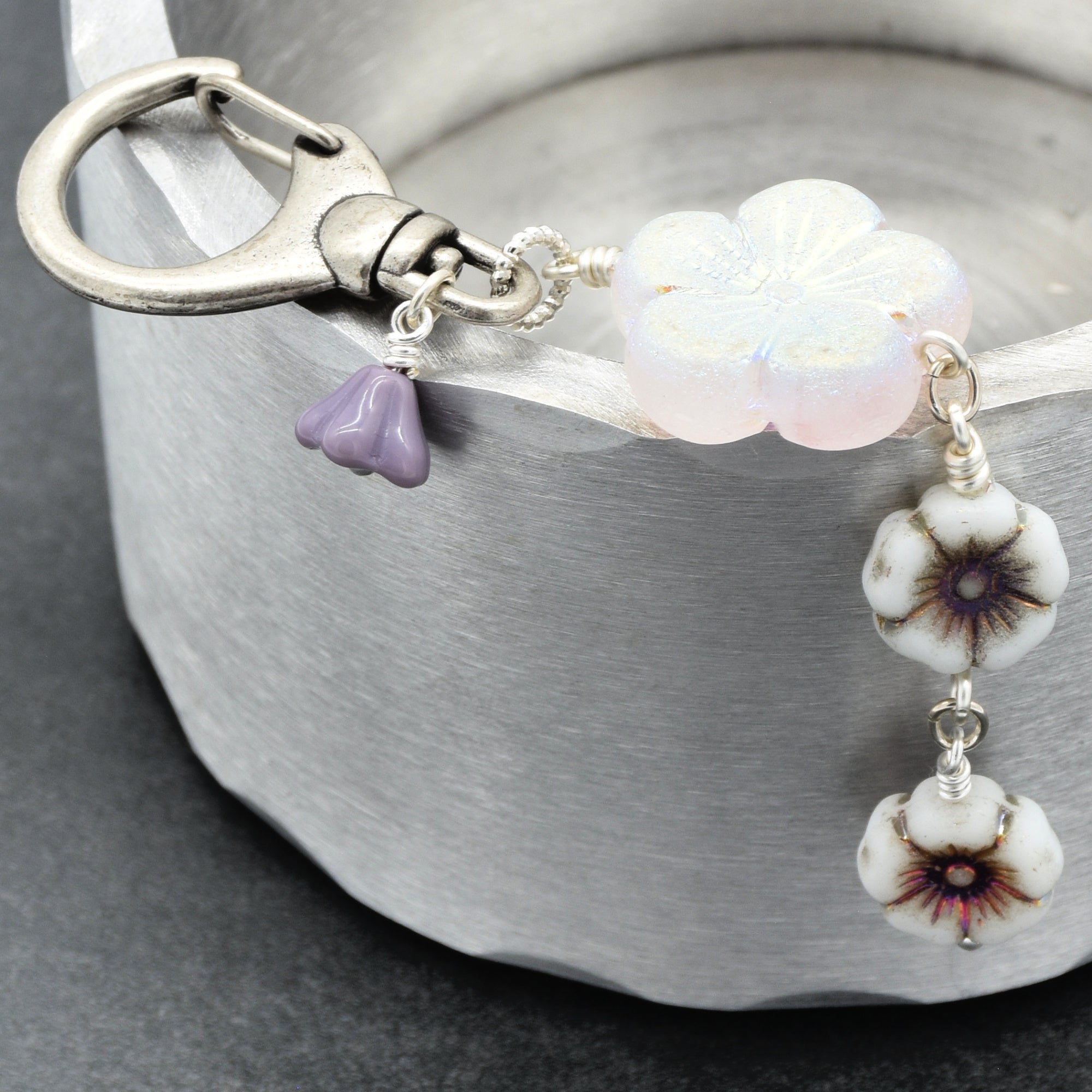 Keychain with floral beads and a silver lobster claw on a gray background