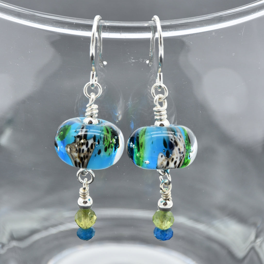 Colorful artisan lampwork glass earrings with sterling silver ear wires, peridot and apatite on a glass surface - handmade with love by Ruby Acorn