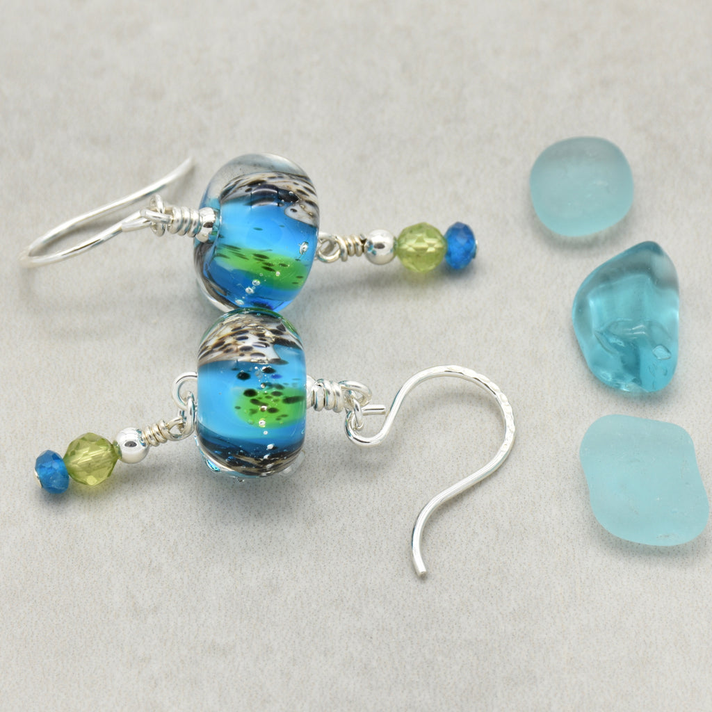 Colorful artisan lampwork glass earrings with sterling silver ear wires, peridot and apatite on a light surface - handmade with love by Ruby Acorn