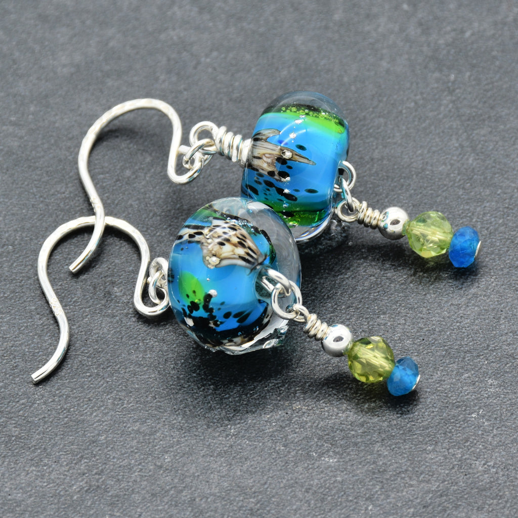 Colorful artisan lampwork glass earrings with sterling silver ear wires, peridot and apatite on a gray surface - handmade with love by Ruby Acorn