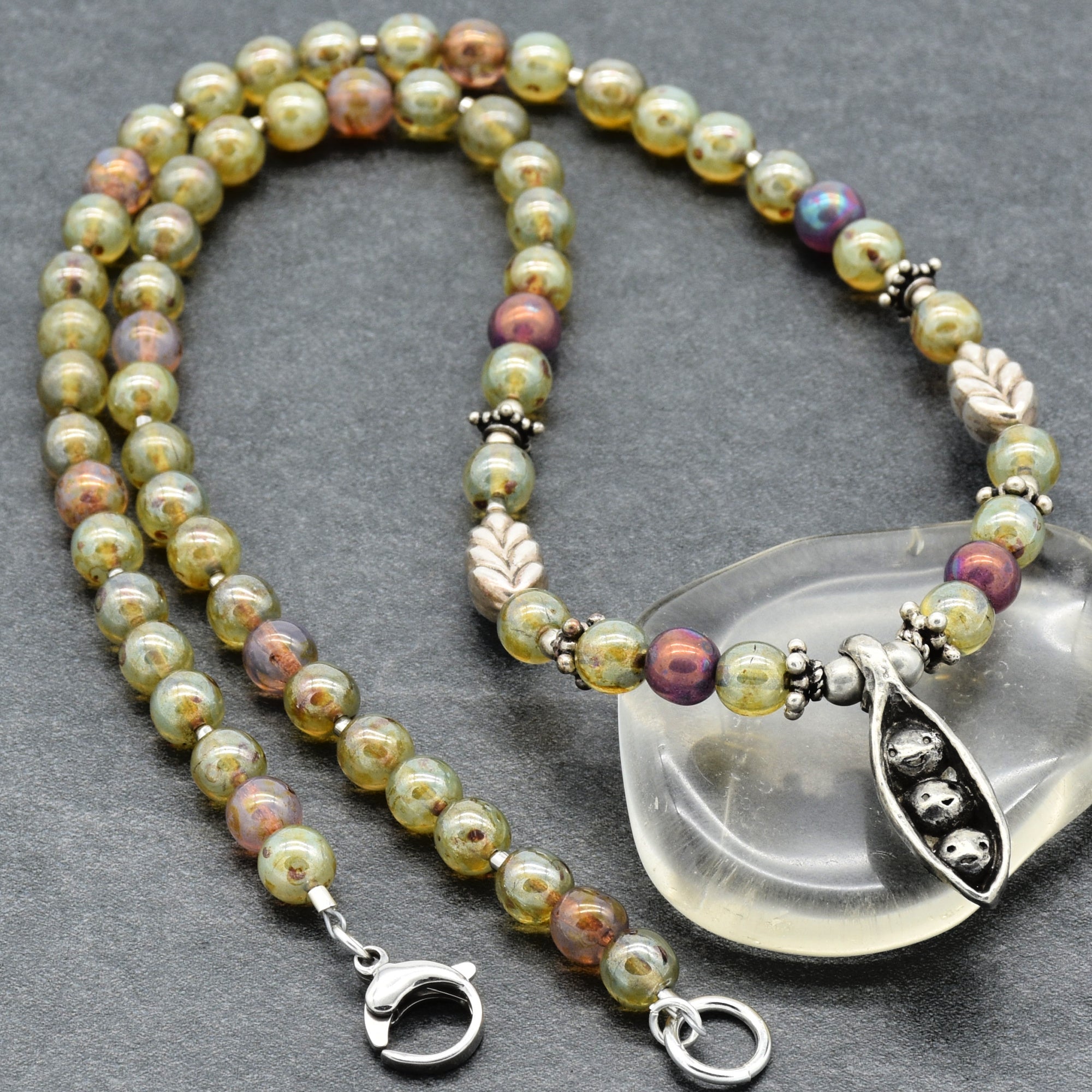 Beaded necklace with silver clasp on a gray background