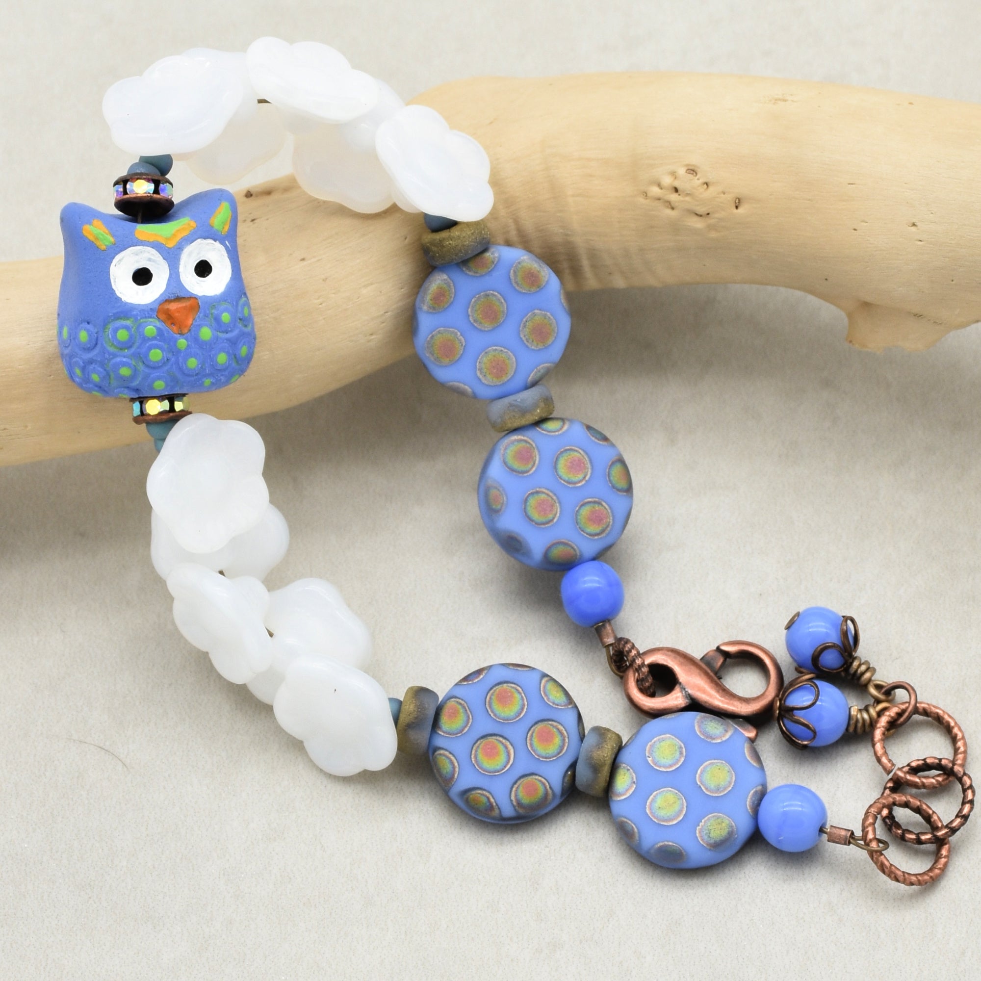 Colorful beaded bracelet with an owl focal on a wooden stick