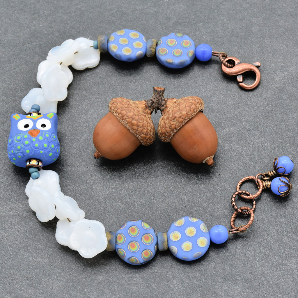 Bracelet with owl focal and patterned beads on a gray background