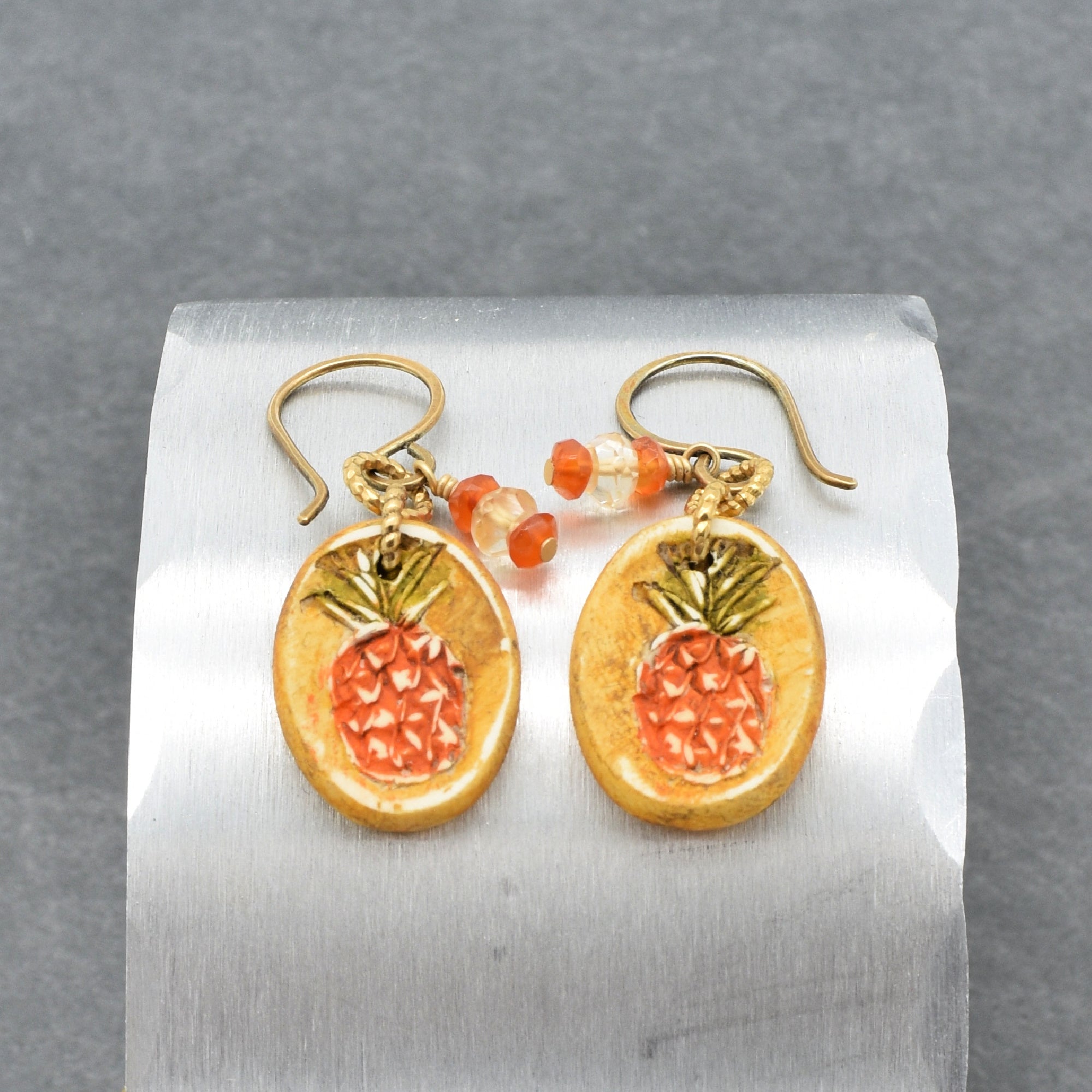 Handmade Pineapple charm earrings with brass ear wires on a silver surface - made with love by Ruby Acorn
