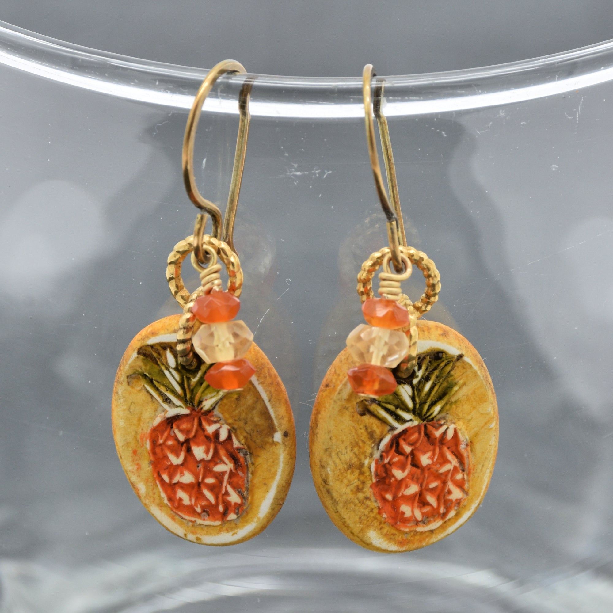 Handmade Pineapple charm earrings with brass ear wires on a glass surface - made with love by Ruby Acorn