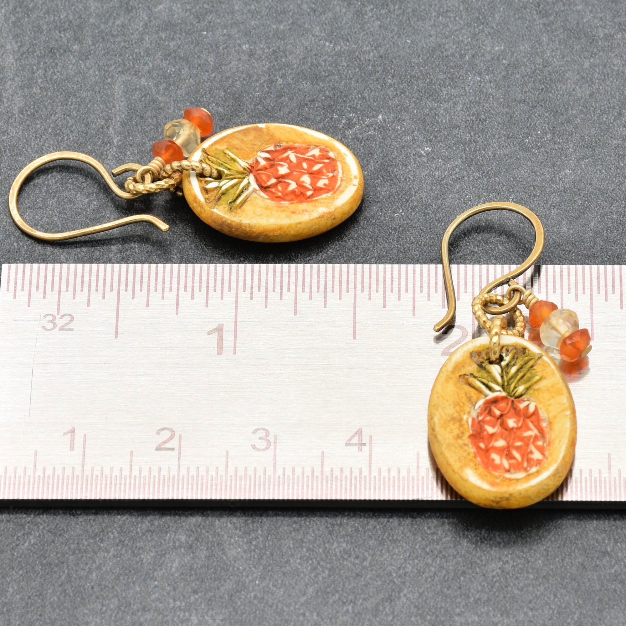 Handmade Pineapple charm earrings with brass ear wires beside a ruler for scale - made with love by Ruby Acorn