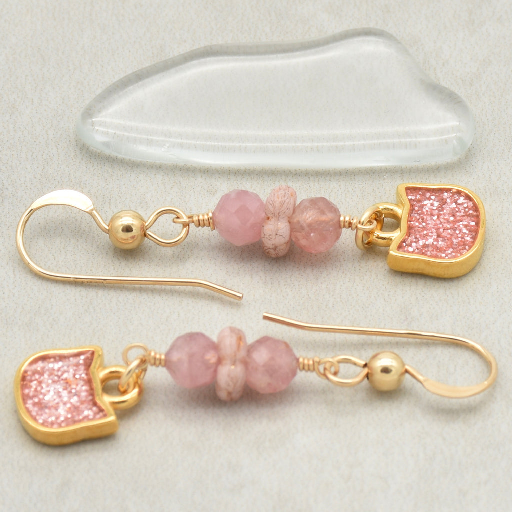 Lovely delicate pink dangle earrings with cat charms, pink tourmaline, and gold ear wires on a light background - handmade with love by Ruby Acorn